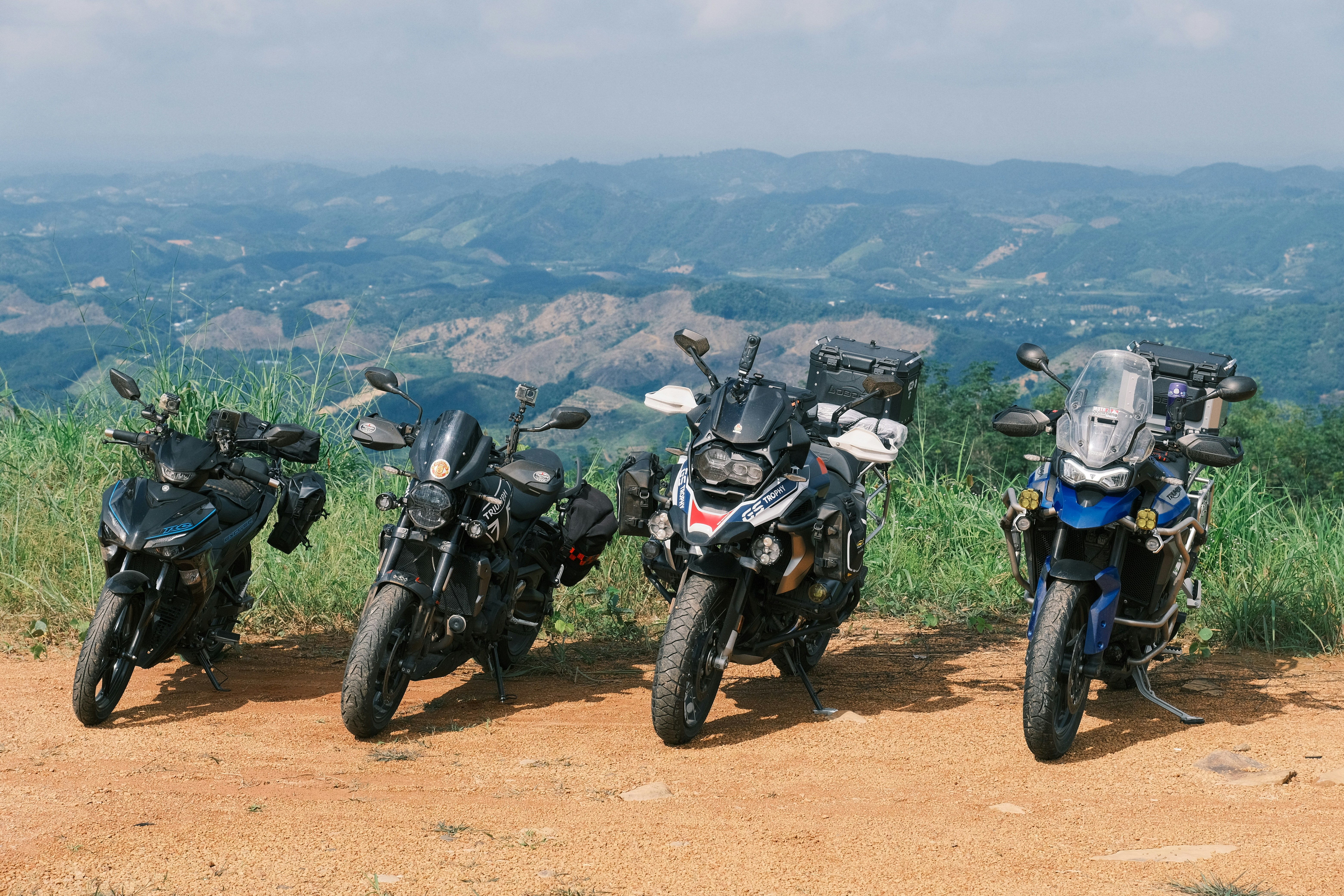 Group of Honda riders on mountain road, adventure motorcycles, dramatic landscape, freedom and camaraderie
