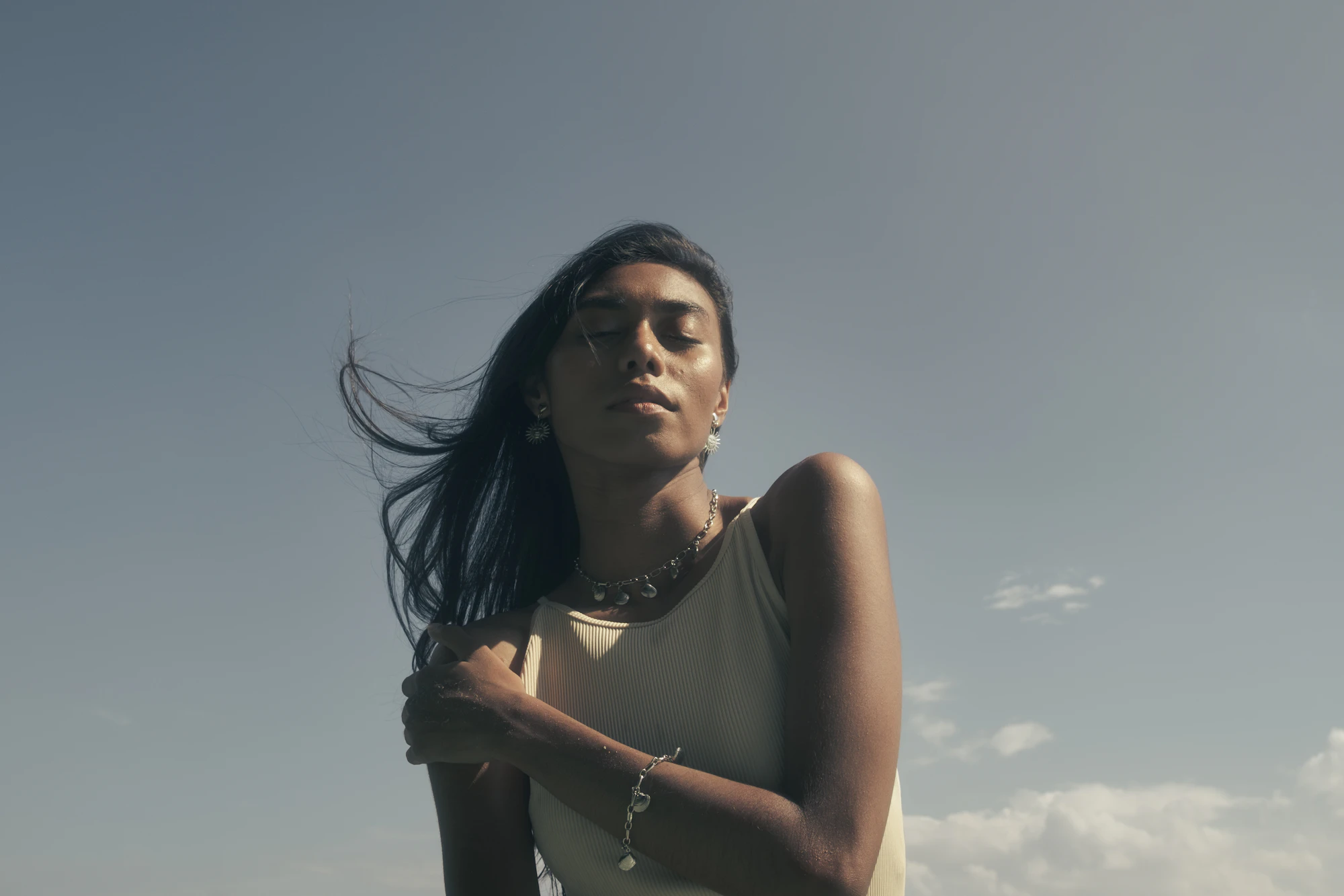 A woman looking up under a grey blue sky