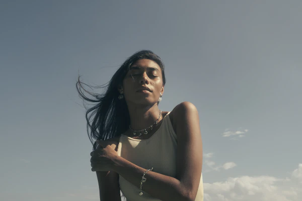 A woman looking up under a grey blue sky