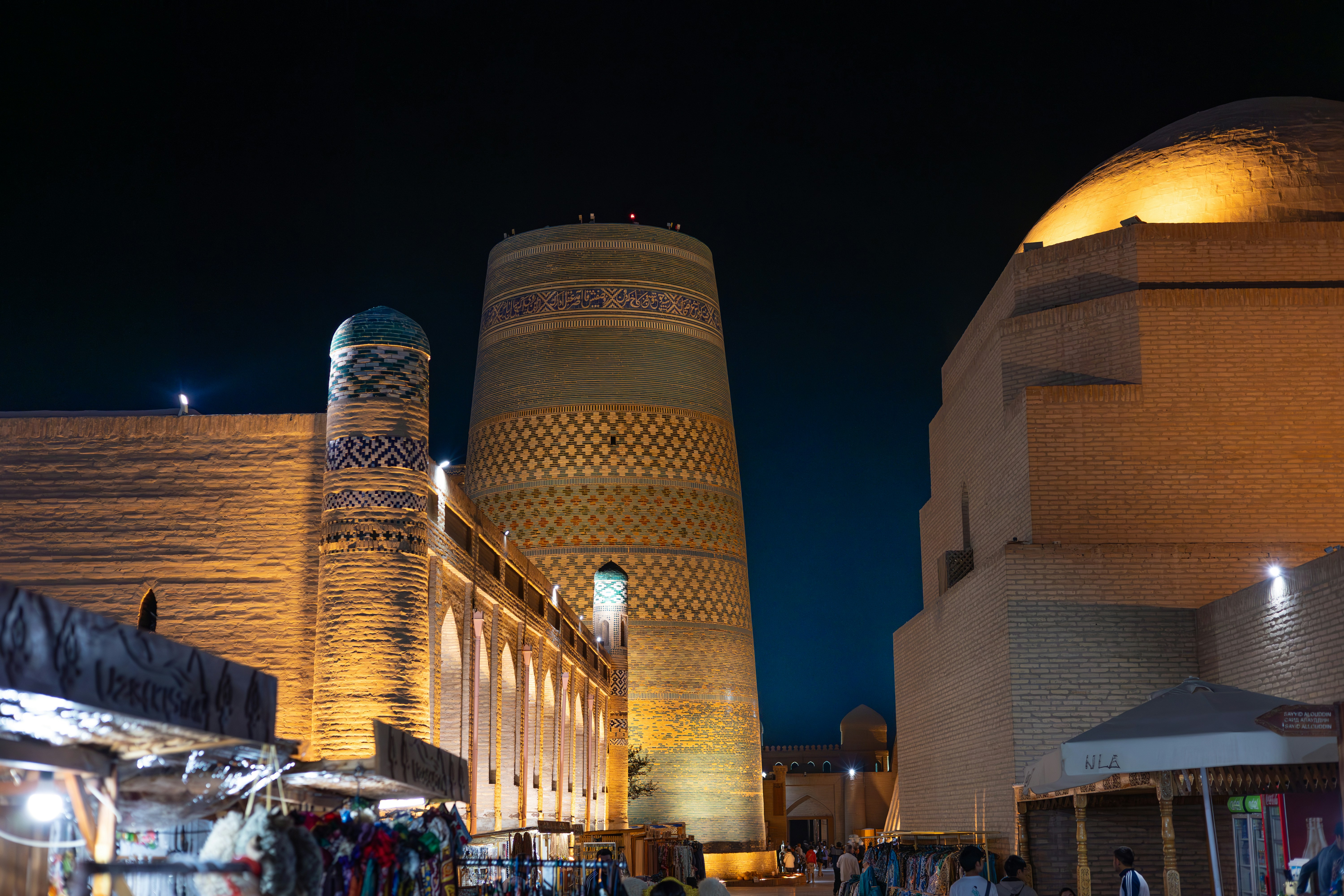 A group of people walking down a street next to tall buildings