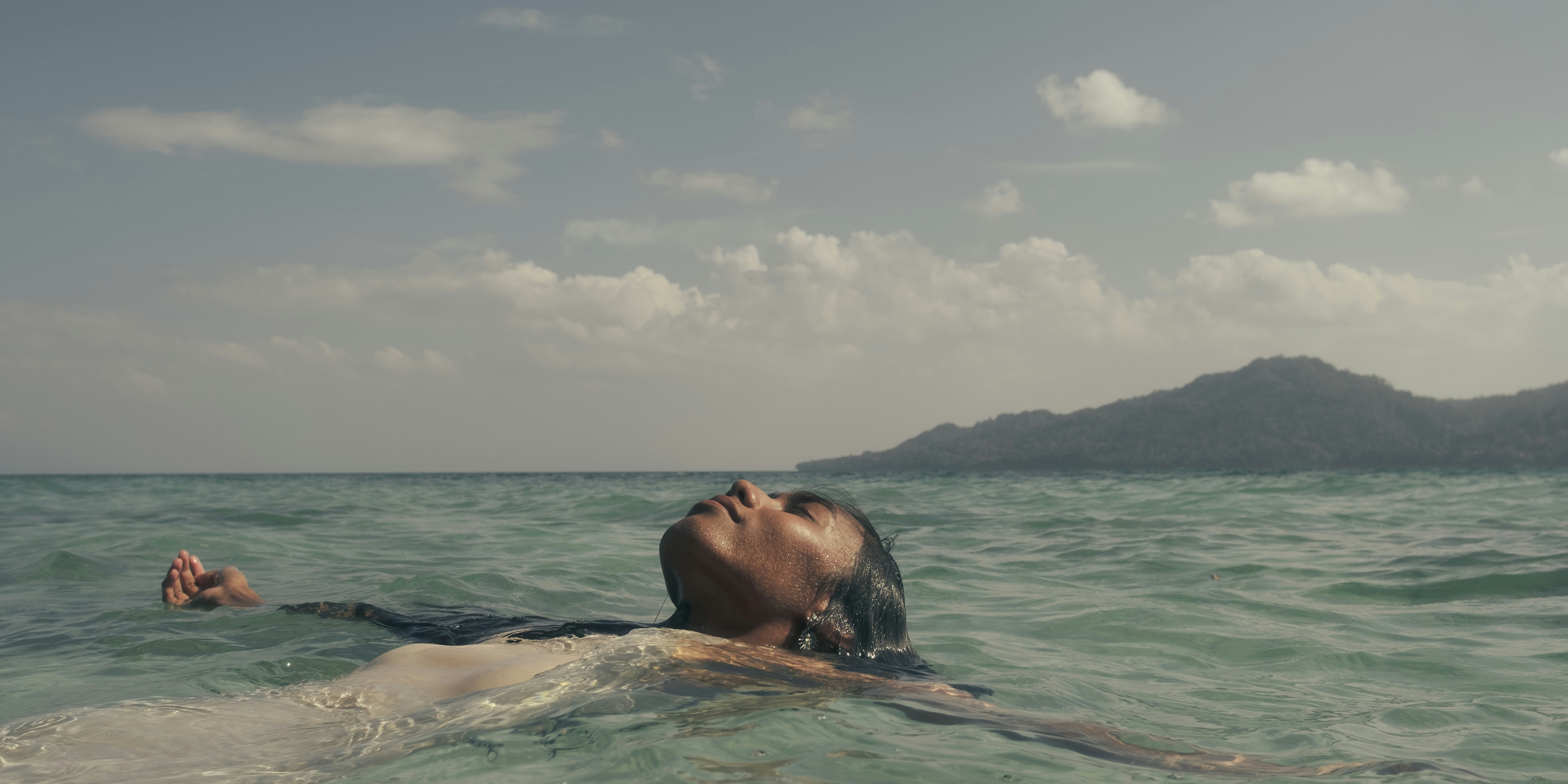 A man floating in the ocean with his head above the water