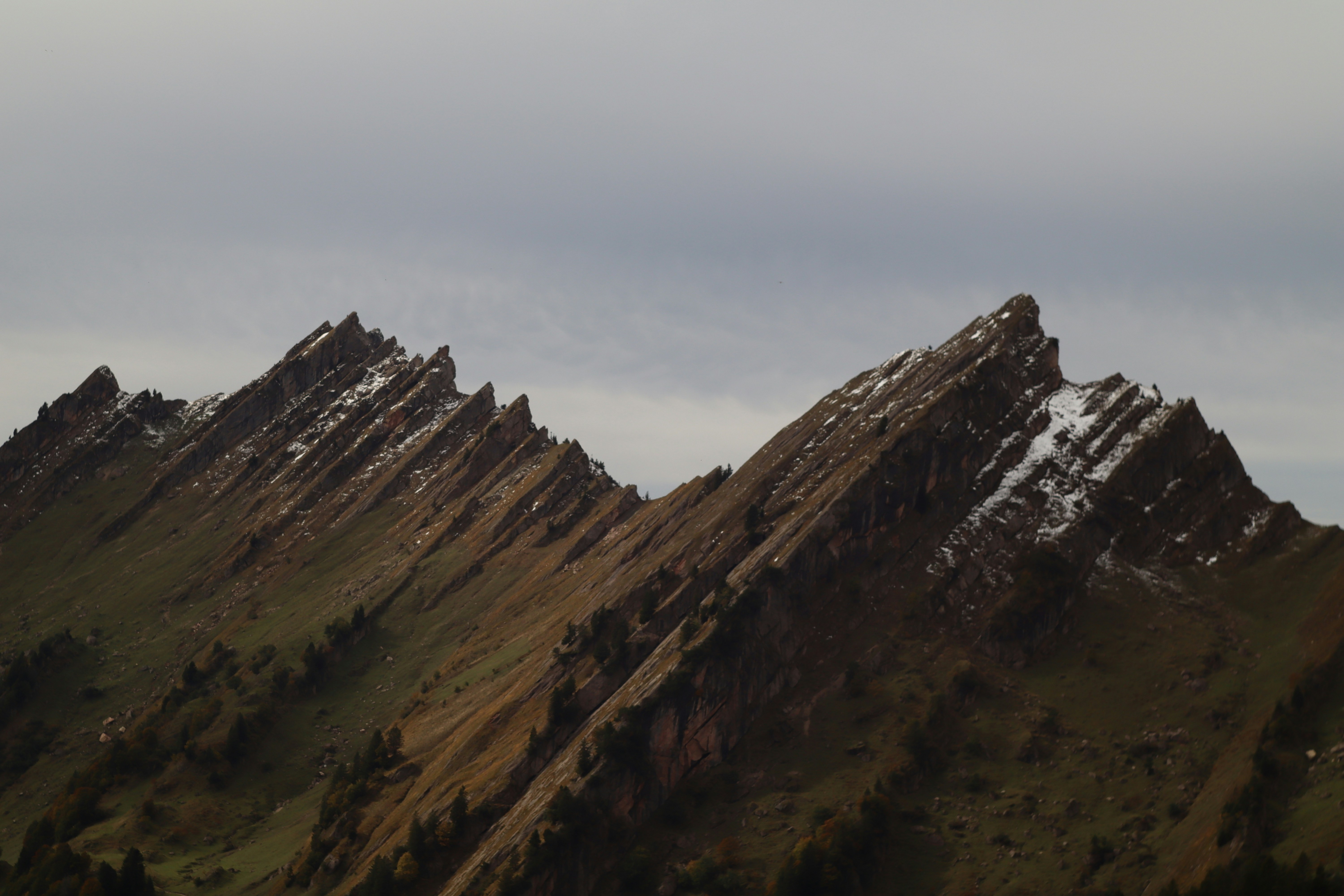 A plane flying over a mountain range in the sky