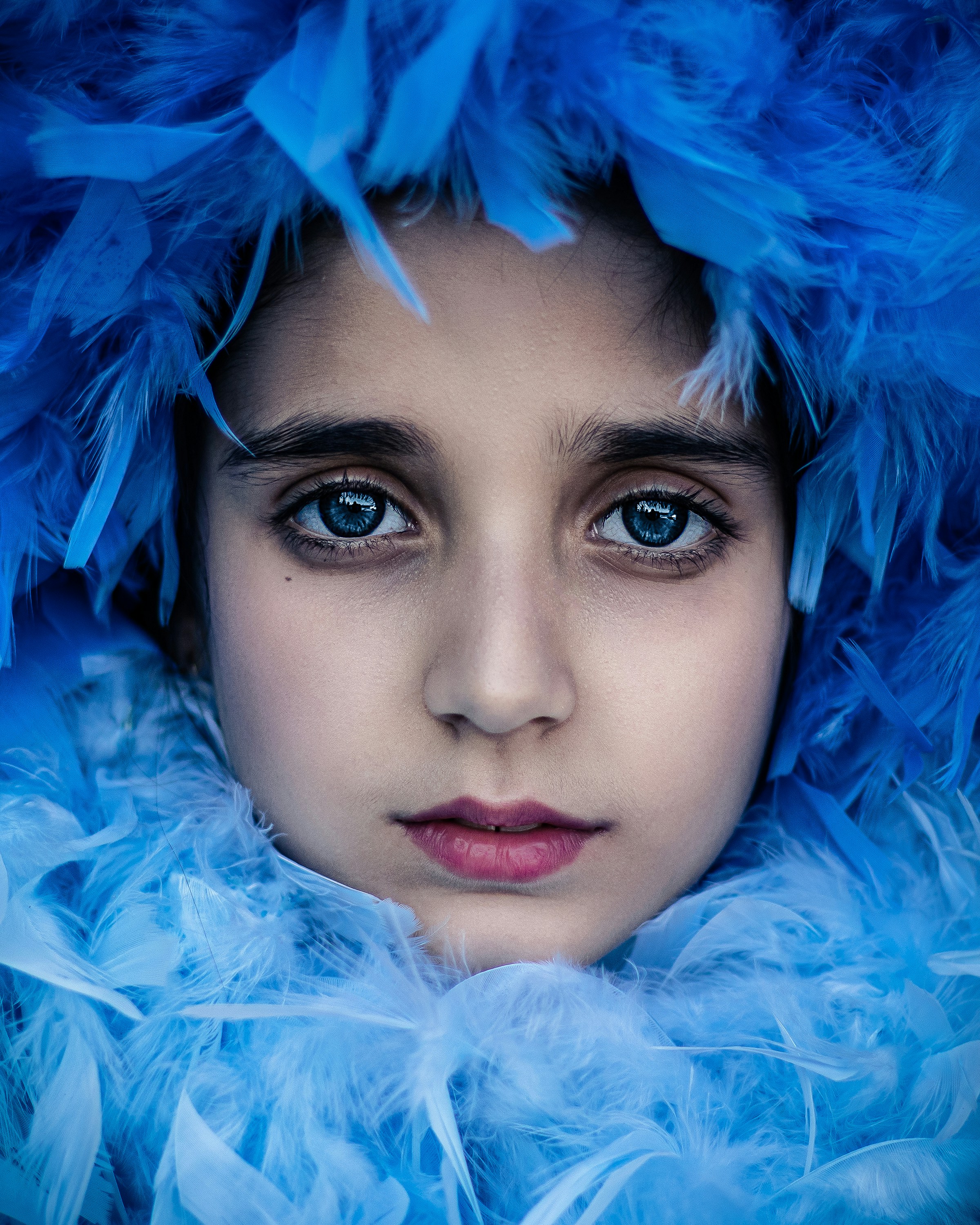A woman with blue feathers on her head