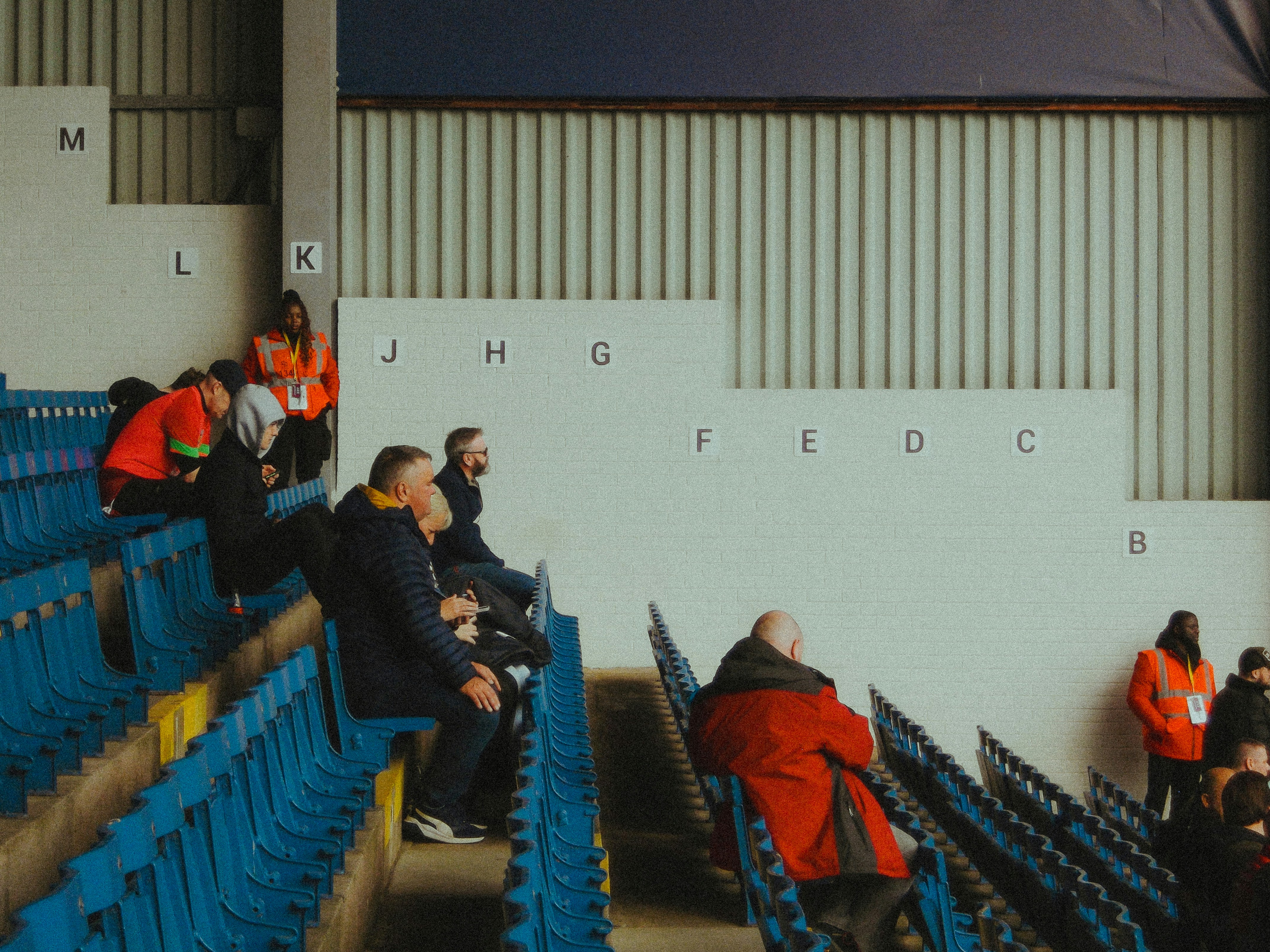 A group of people sitting in the stands at a soccer game