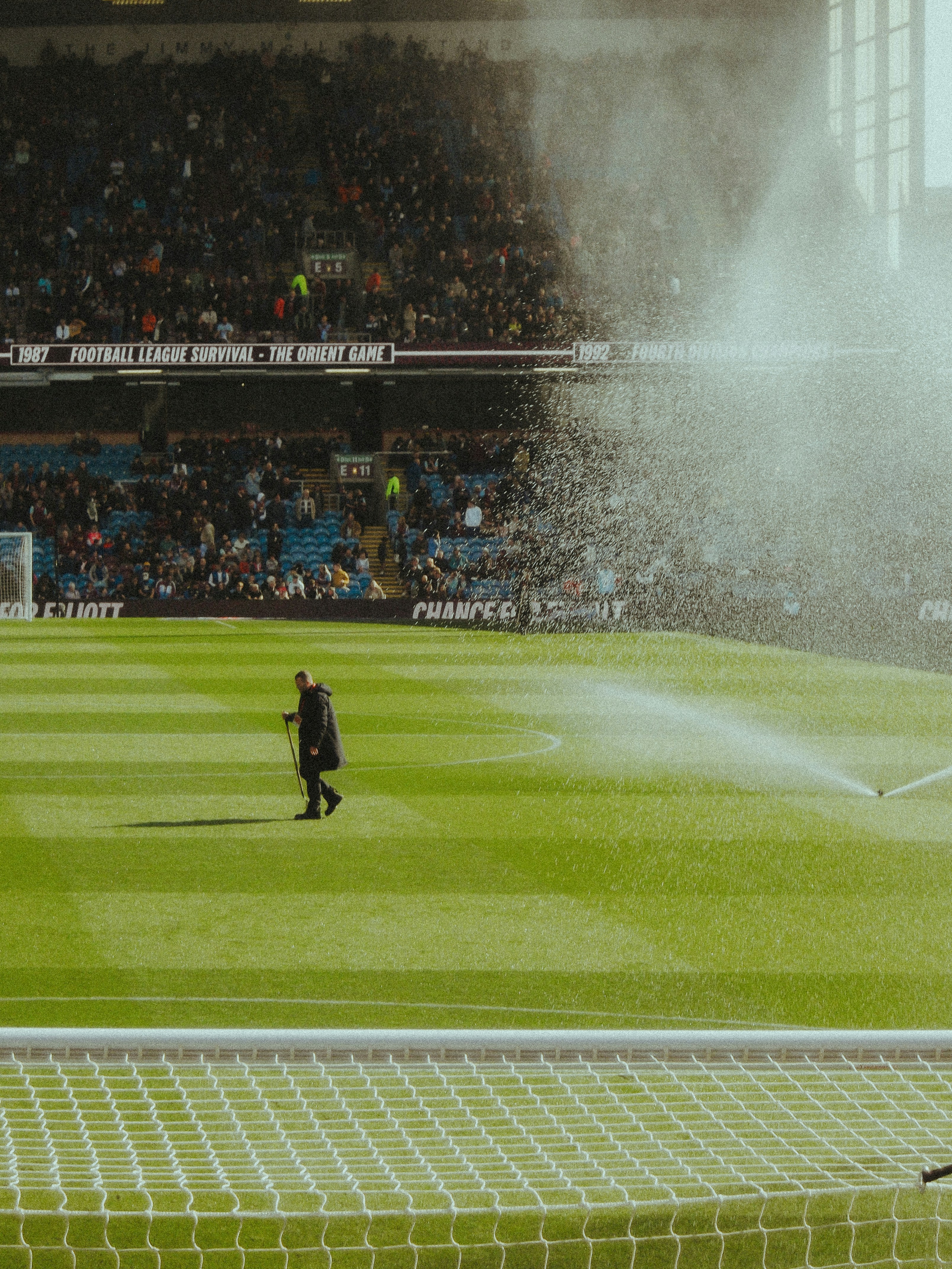 A man is spraying water on a soccer field