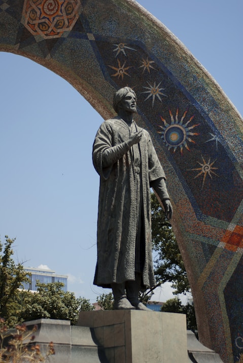 A statue of a man standing next to a large piece of art