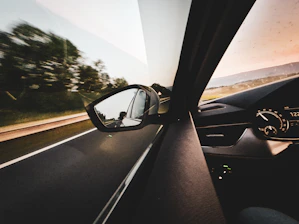 A view of a car's rear view mirror from inside a vehicle