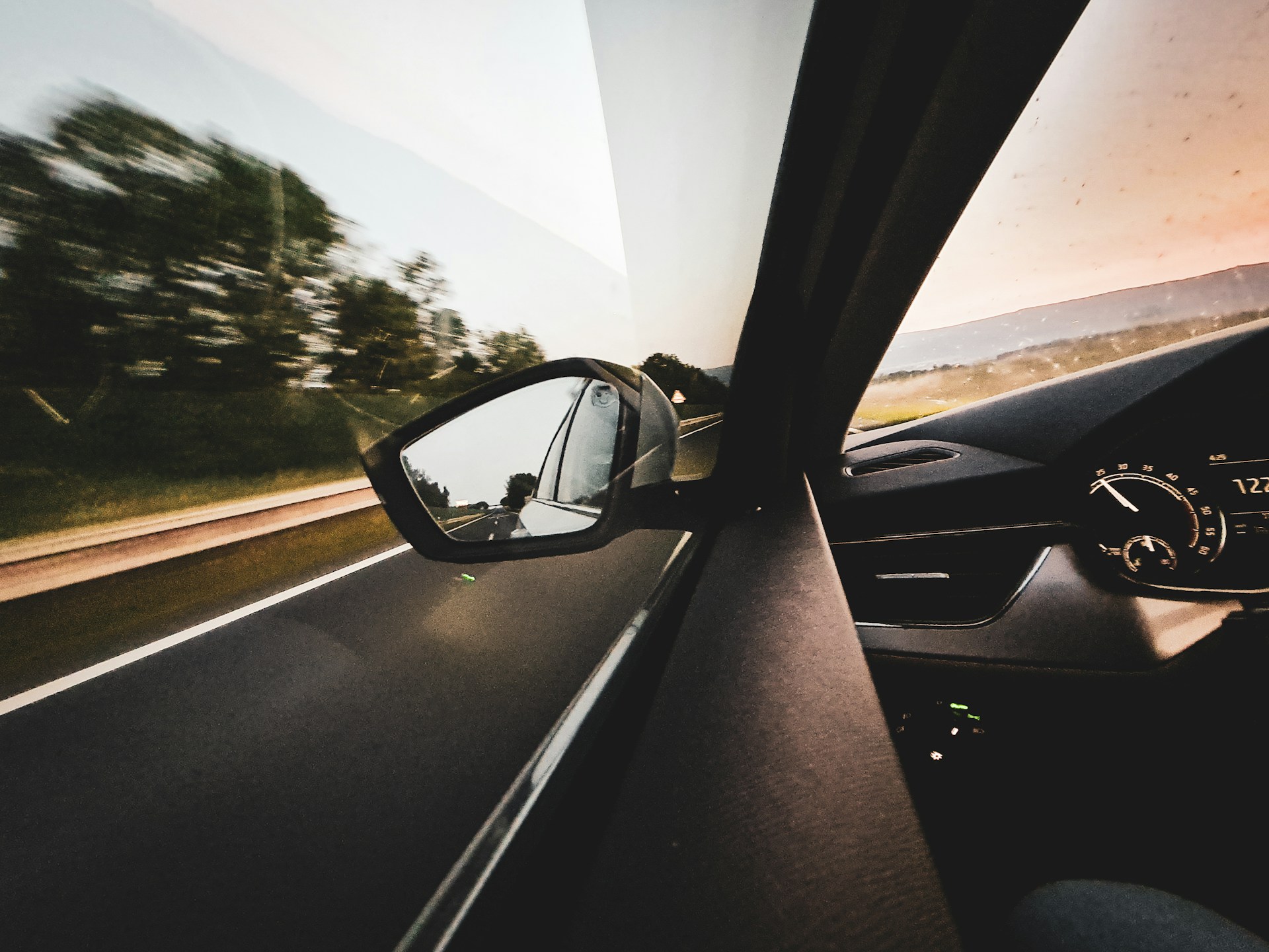 A view of a car's rear view mirror from inside a vehicle