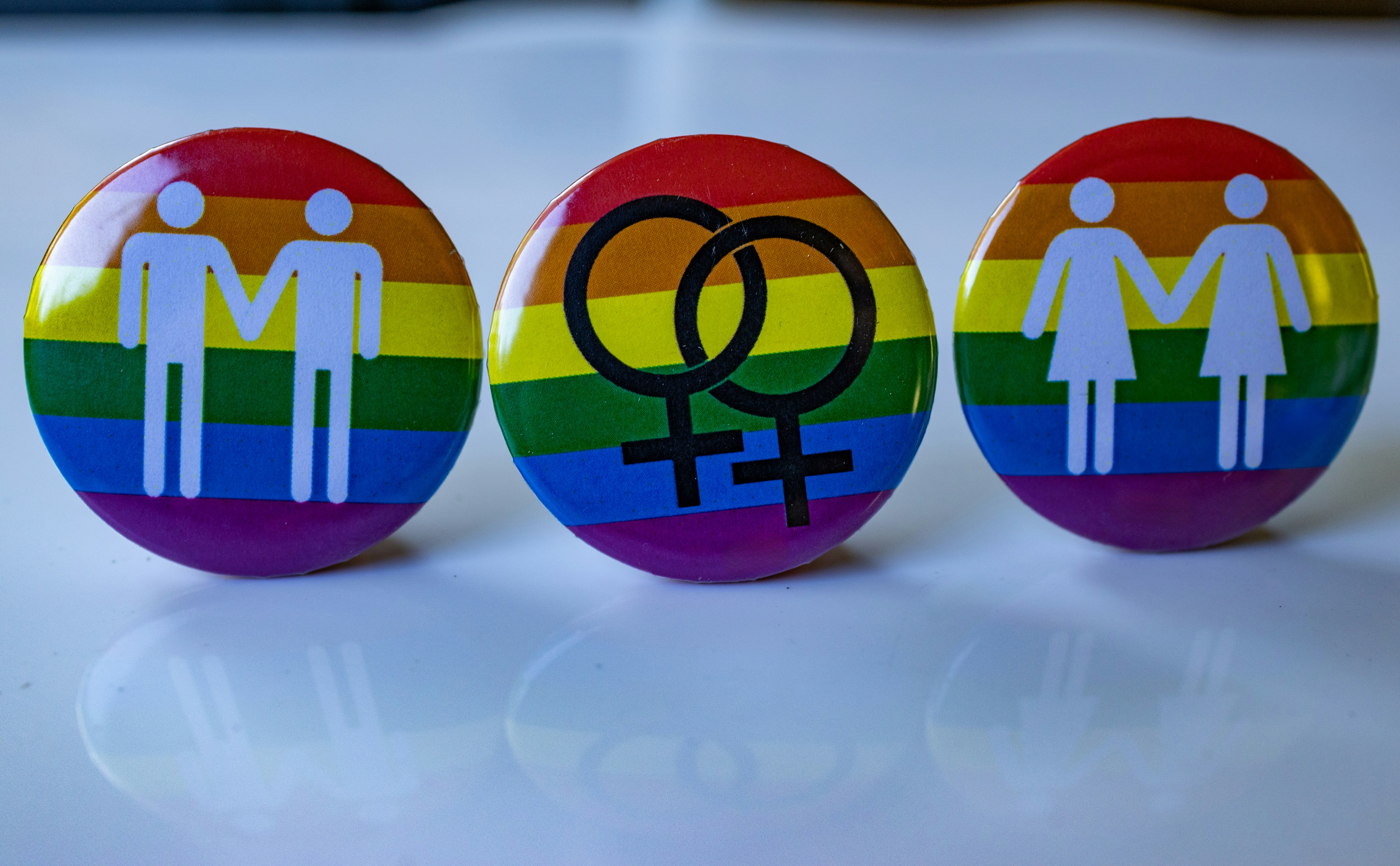 Three pins with a picture of a man and a woman on them, Gender buttons with gender symbols