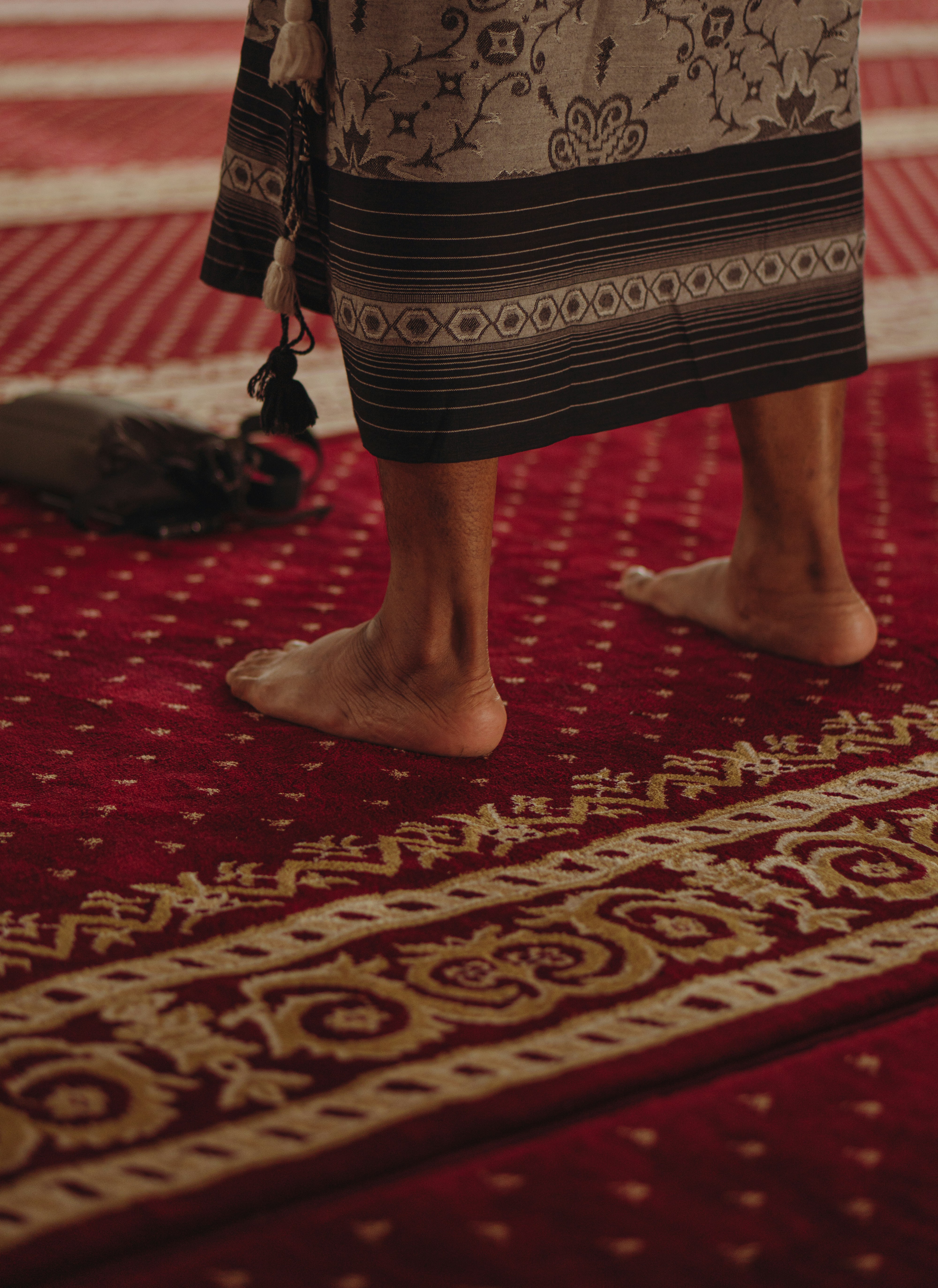 Man in sarong doing prayer (standing).