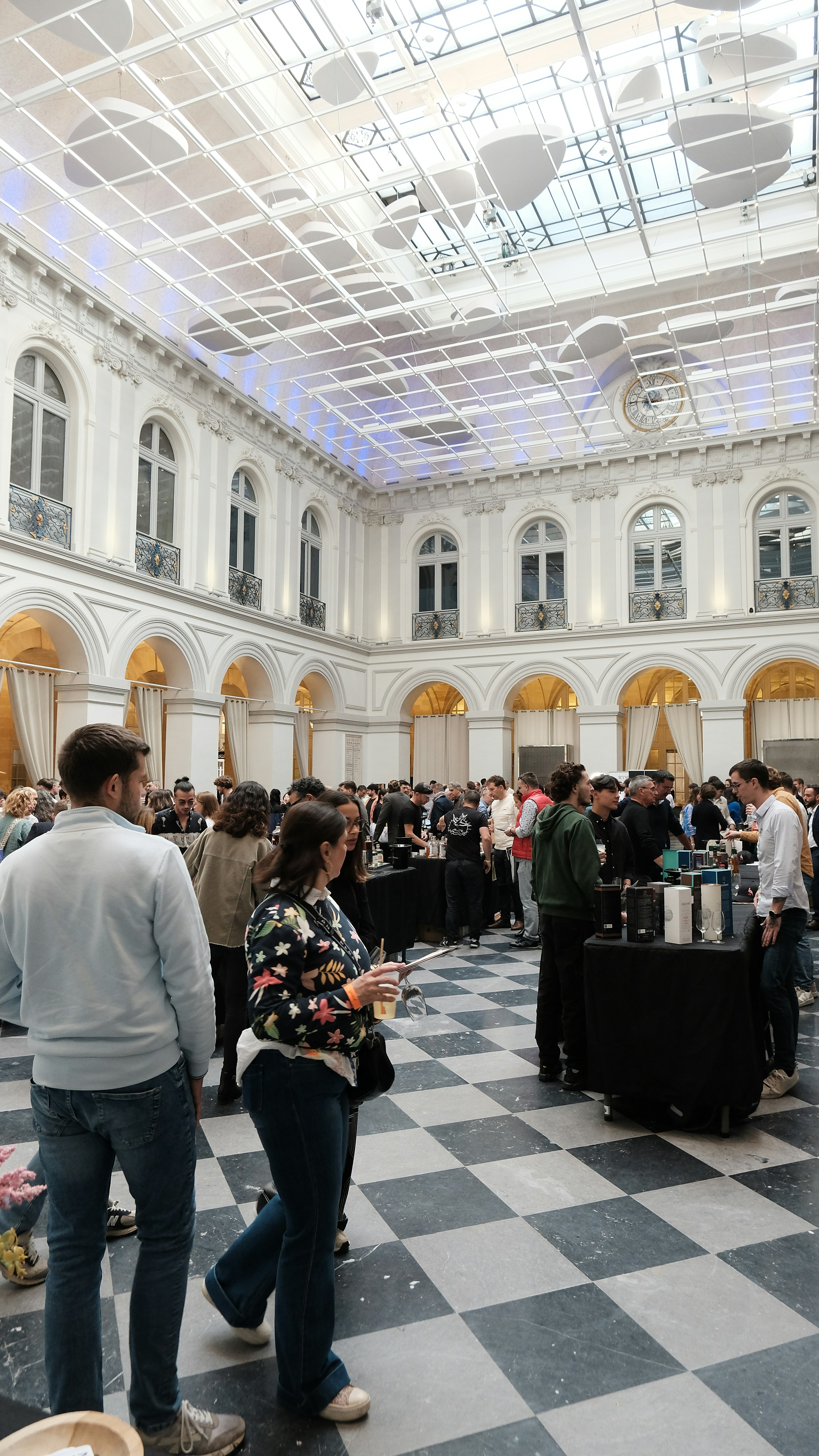 Des gens réseautent lors d'un événement élégant dans un grand hall.