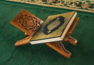 An open book sitting on top of a wooden stand