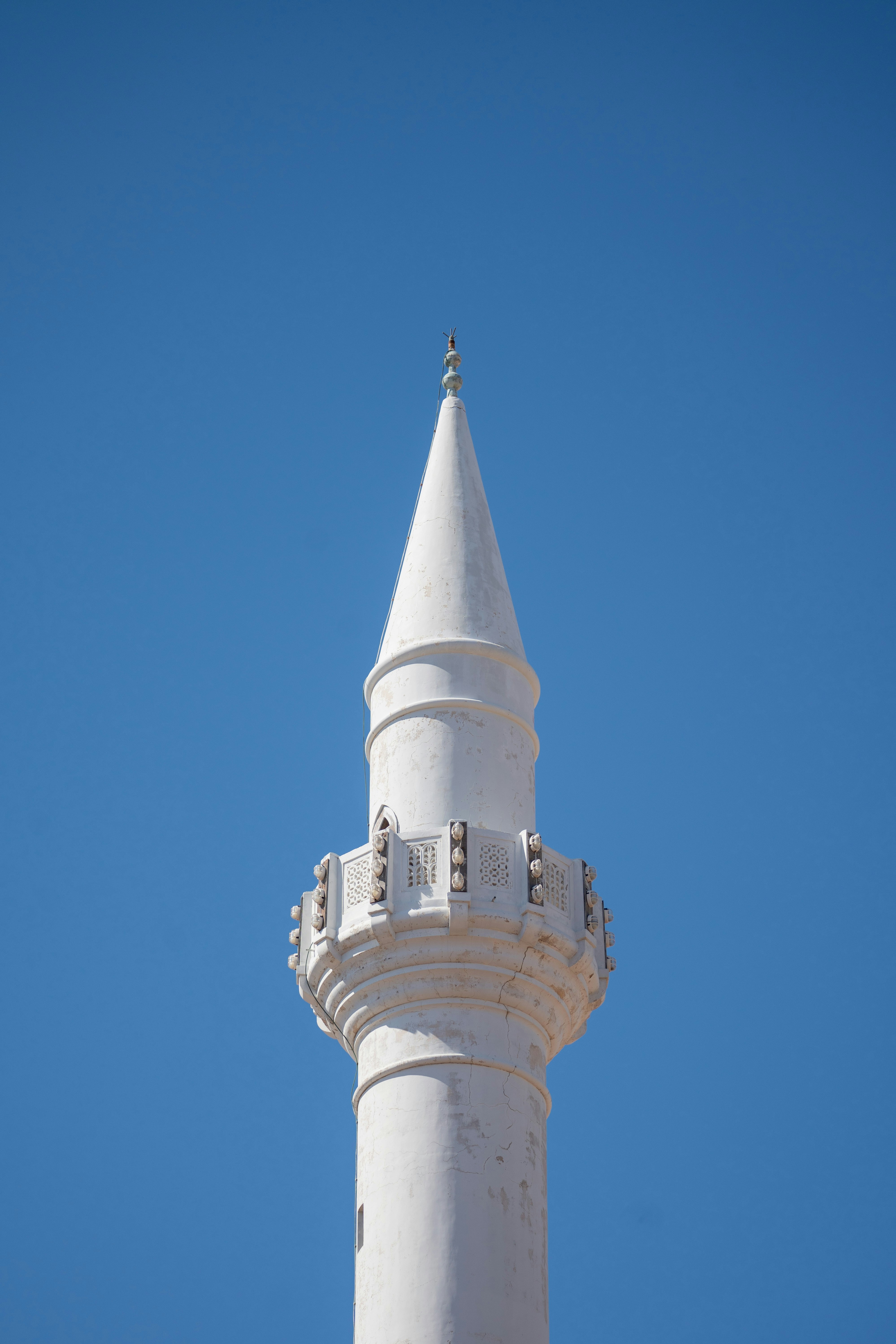 A tall white tower with a sky background