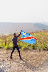 A man holding a flag in a field