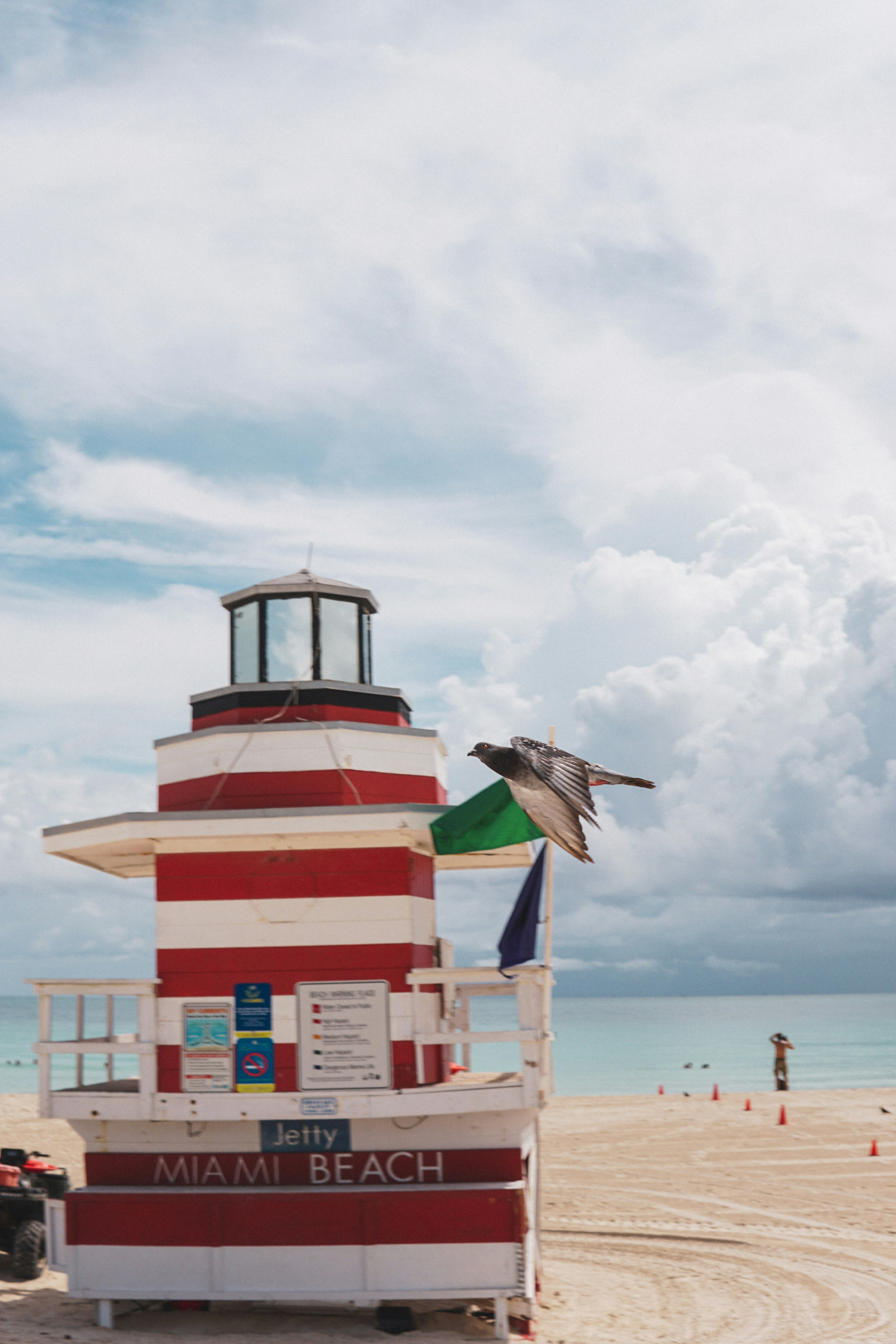 A red and white striped lifeguard tower on a beach