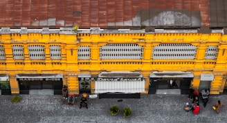 An overhead view of a yellow building with people walking around