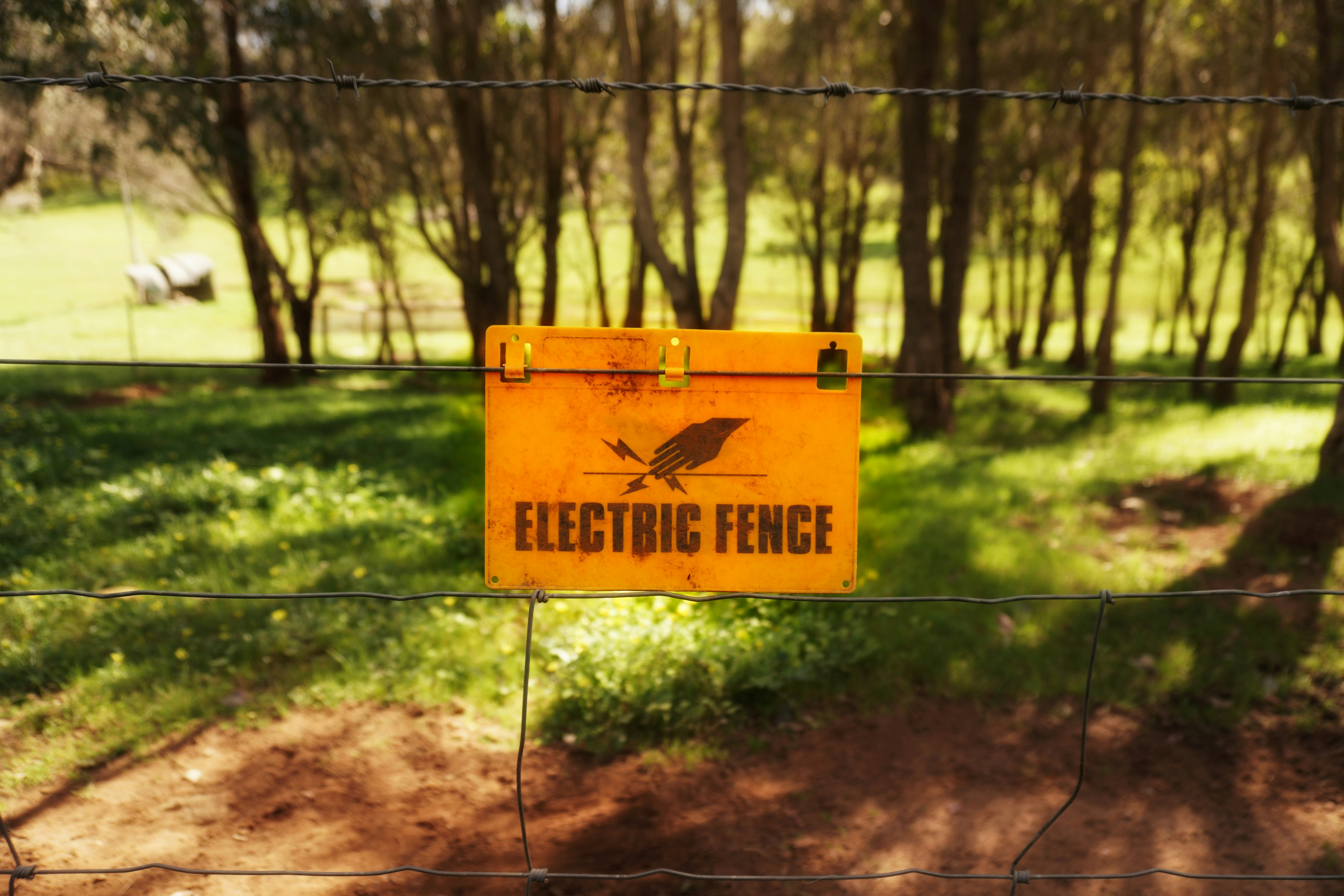 A sign on a fence that reads electric fence