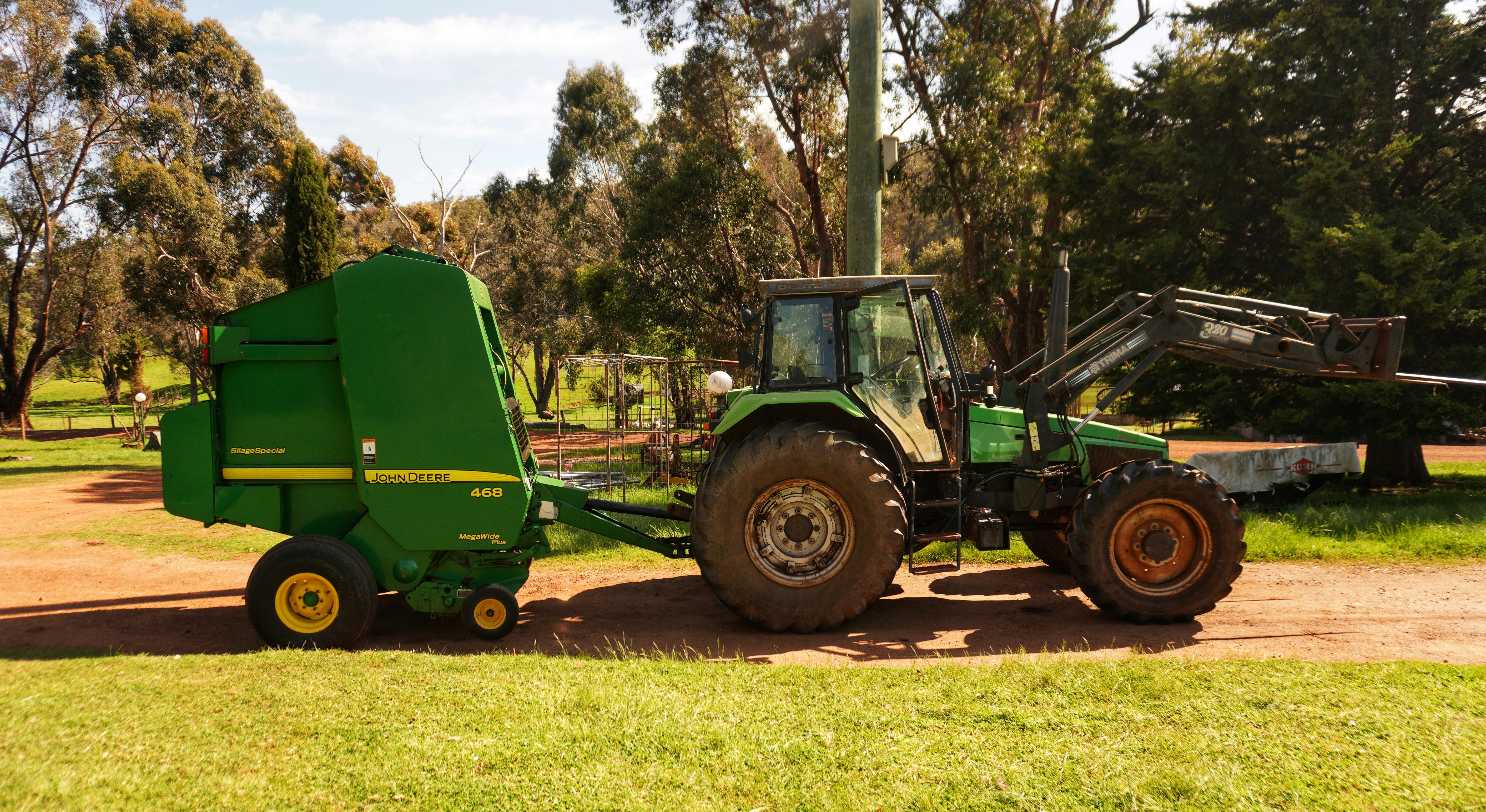 A tractor pulling a trailer behind it on a dirt road