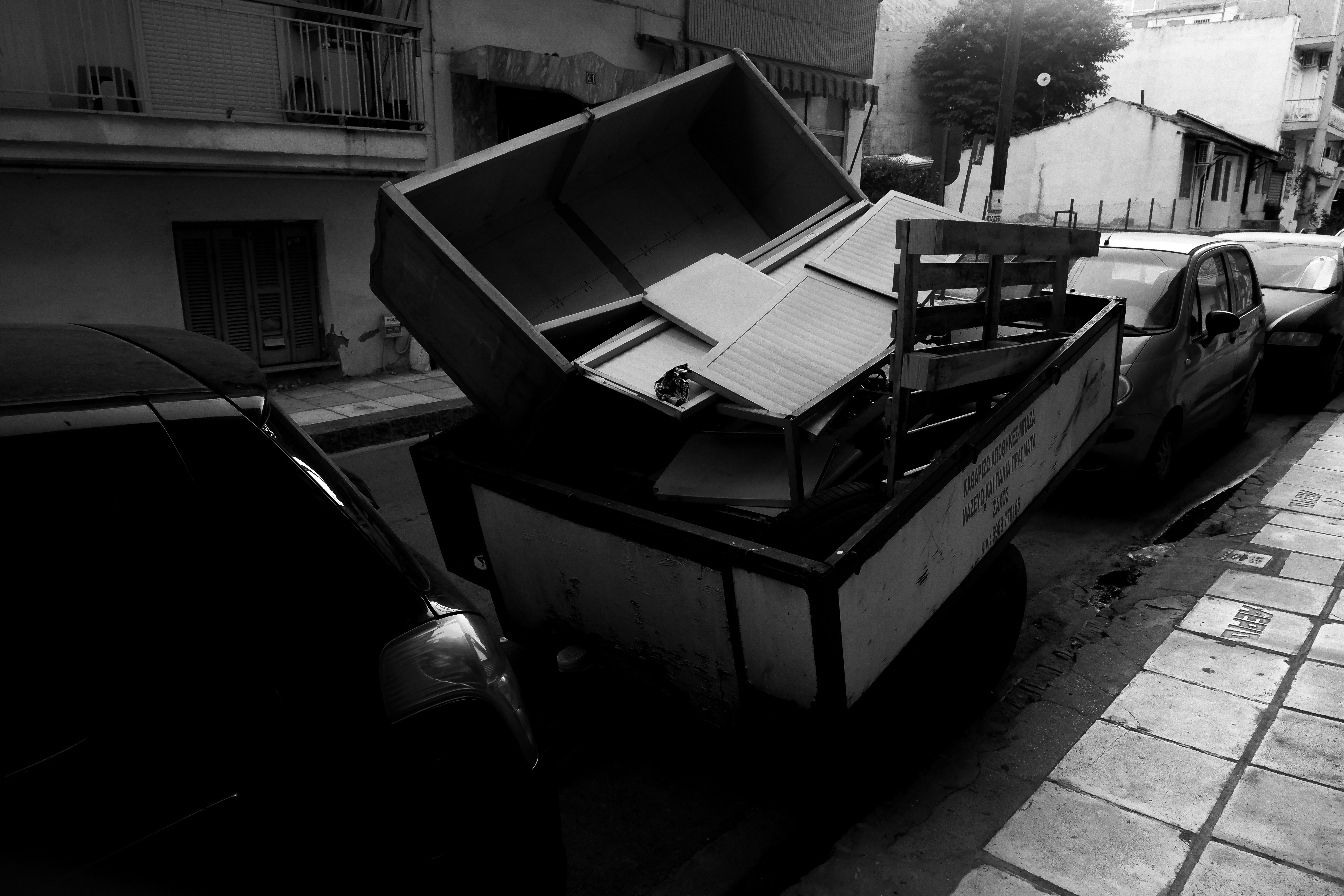 A black and white photo of a suitcase on the side of the road