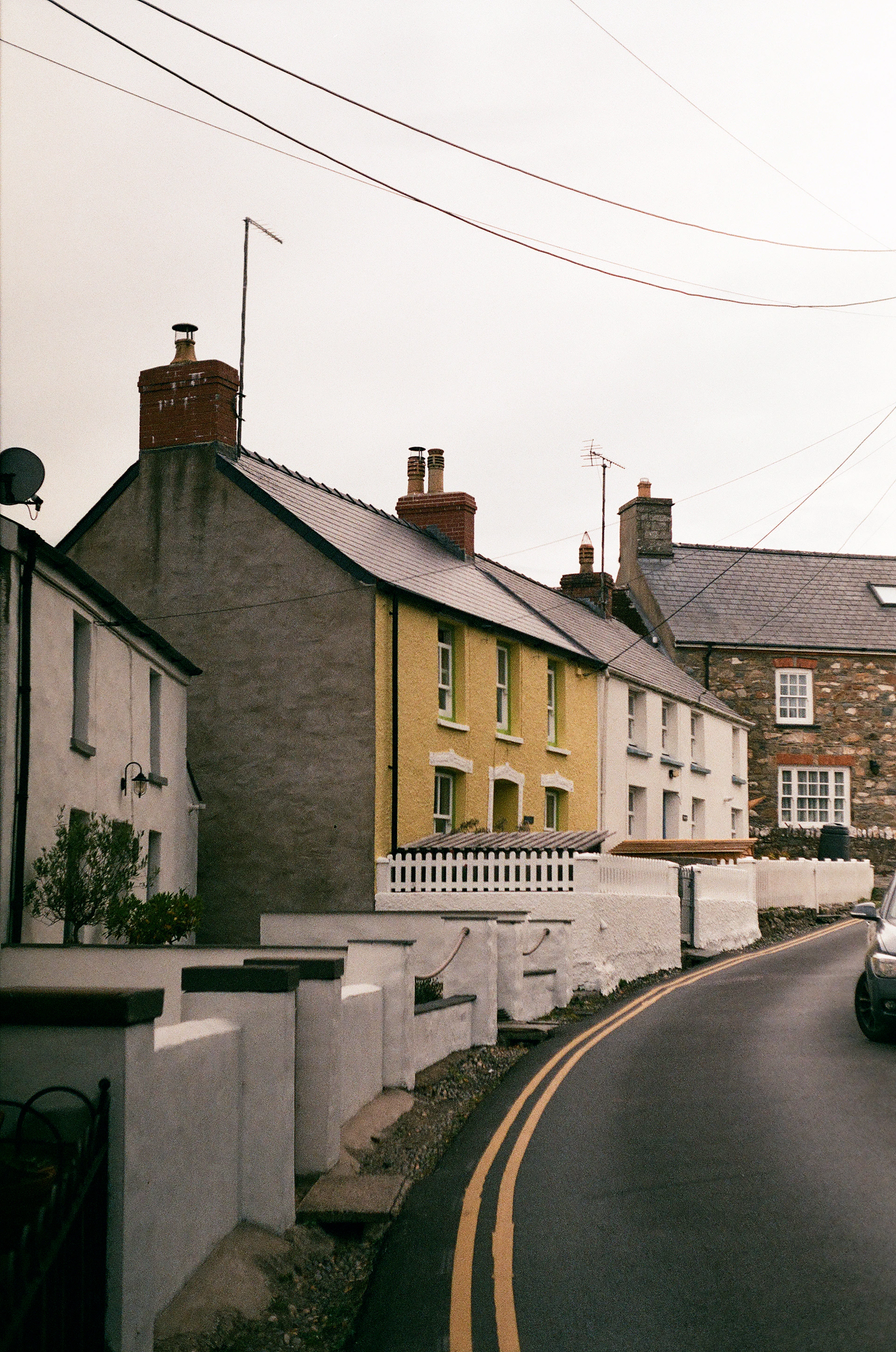 A car is driving down a narrow street