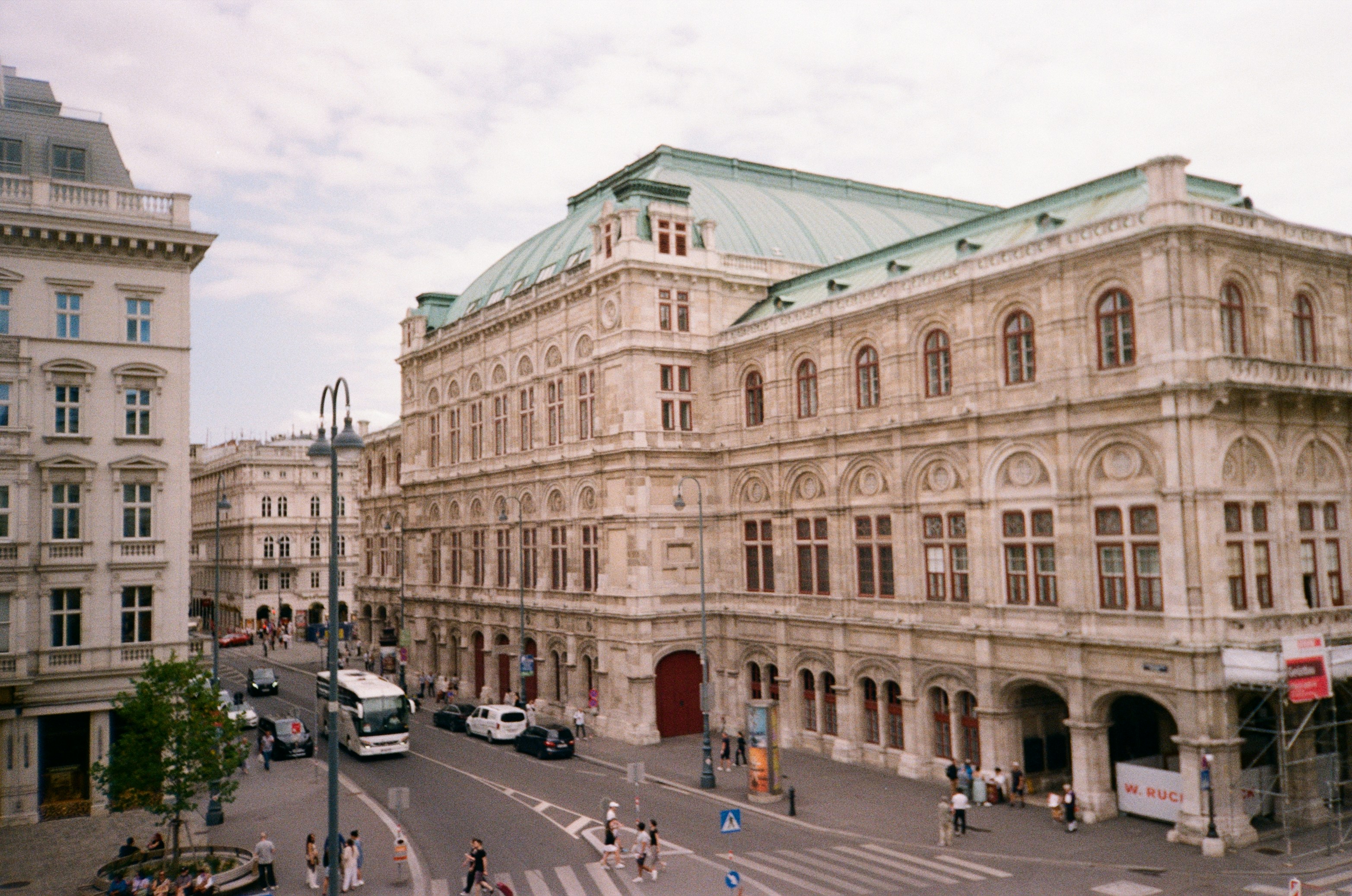 A large building with a green roof next to a street