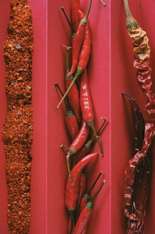 Three different types of chili peppers on a red background
