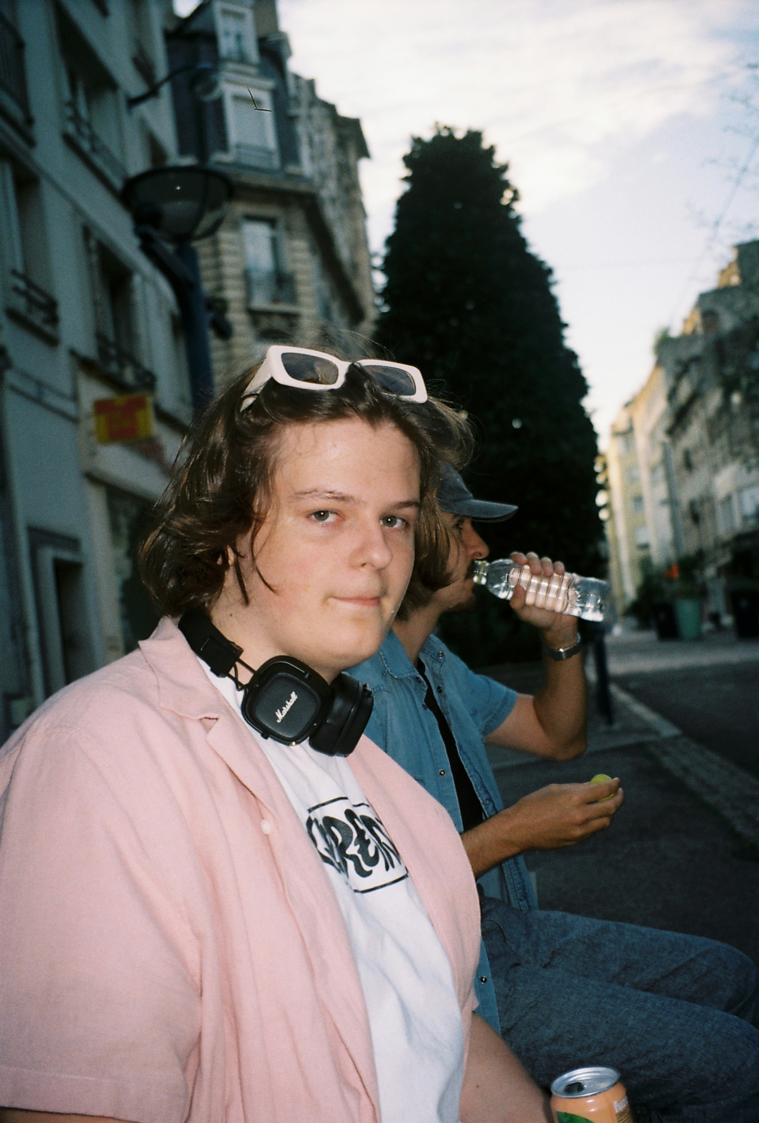 A man with headphones and a woman with a drink
