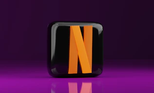 A black and orange letter n on a purple background
