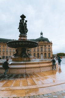 A group of people standing around a fountain