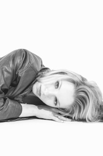 A black and white photo of a woman laying on the ground