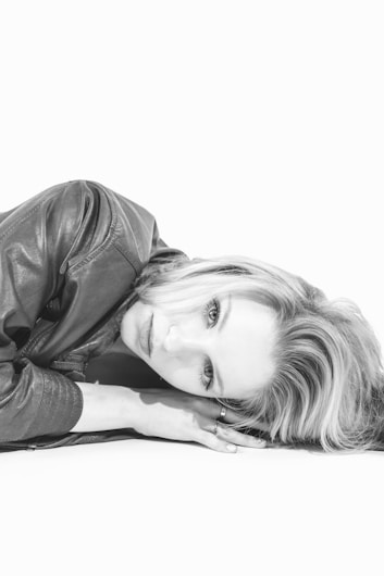 A black and white photo of a woman laying on the ground