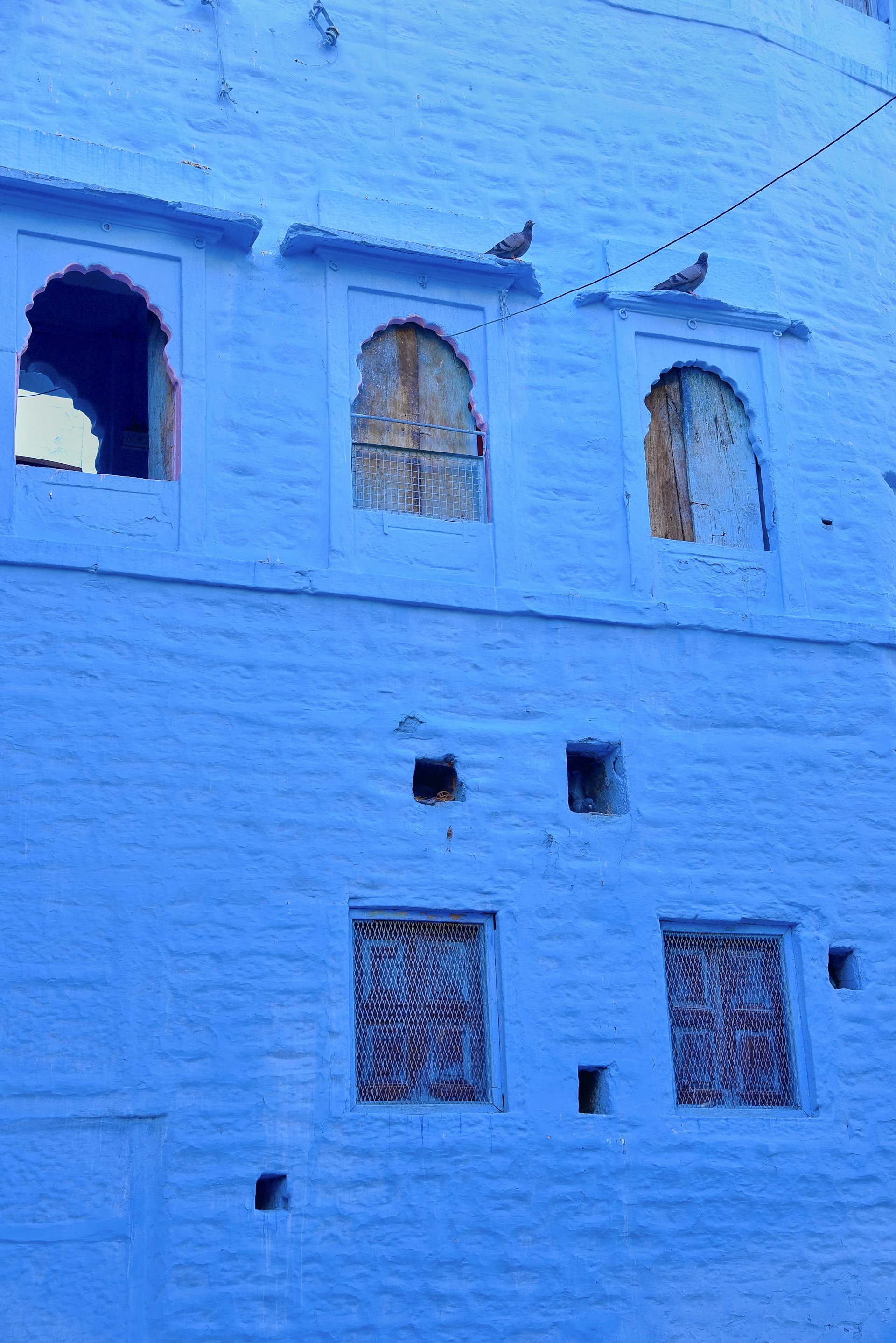 A blue building with a clock on the side of it