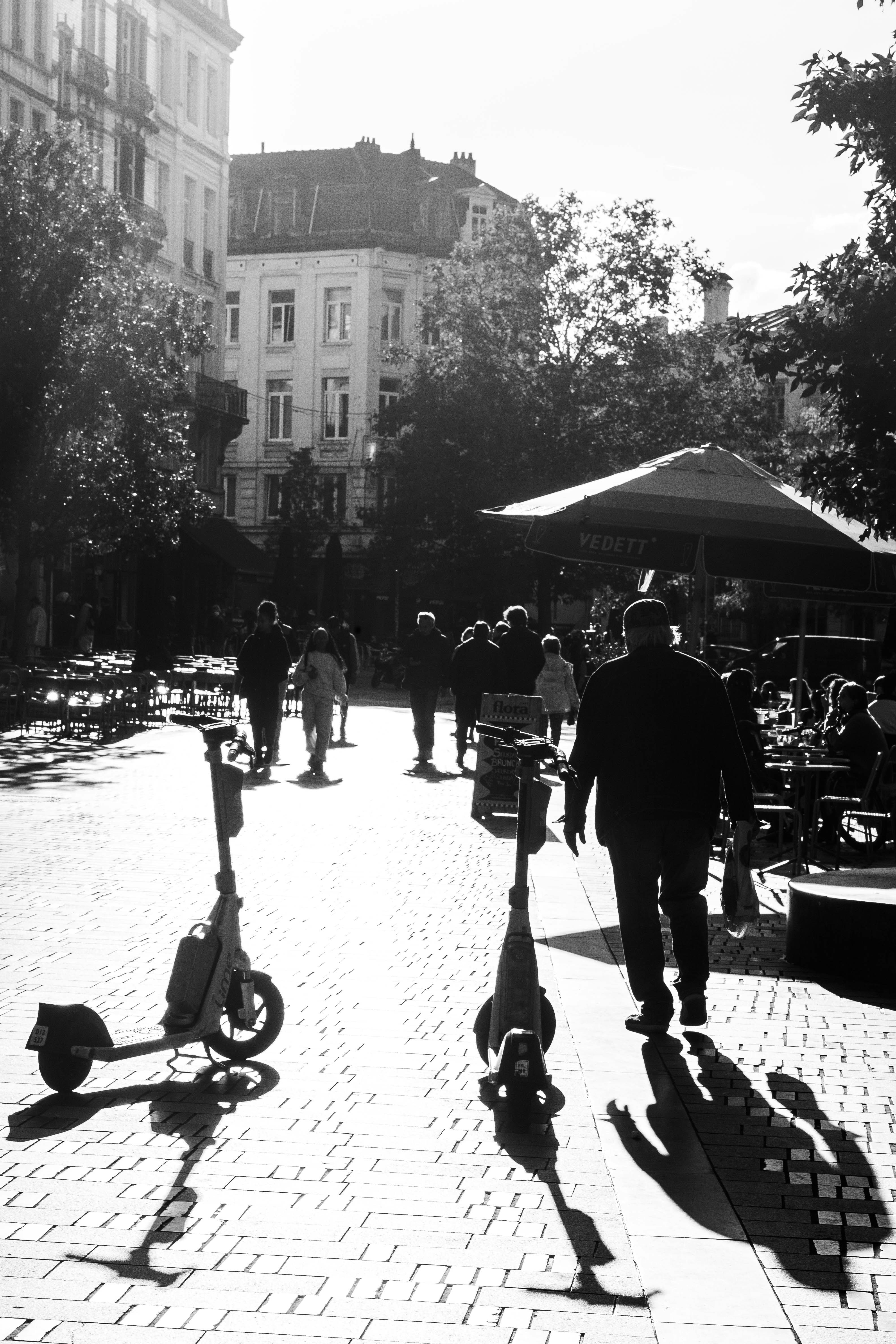 A black and white photo of people walking down a street