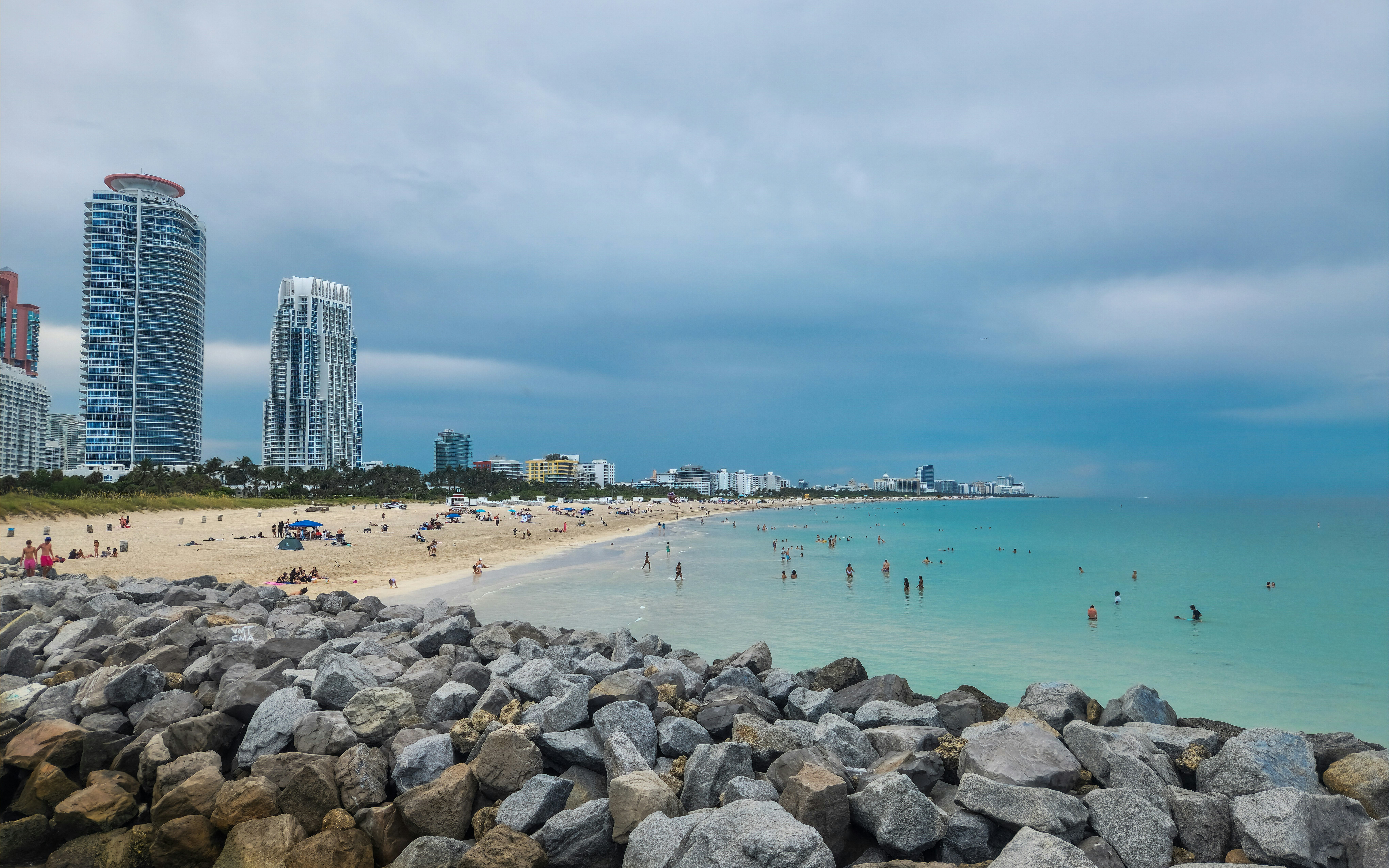 A beach with a bunch of rocks in the foreground, South Pointe beach has colorful lifeguard towers, and umbrella and beach chair rentals are available. This is a popular spot for locals to surf, play volleyball and paddle board. Pets are not allowed on the beach. Restrooms, outdoor showers and the South Pointe Cafe are located near the kids