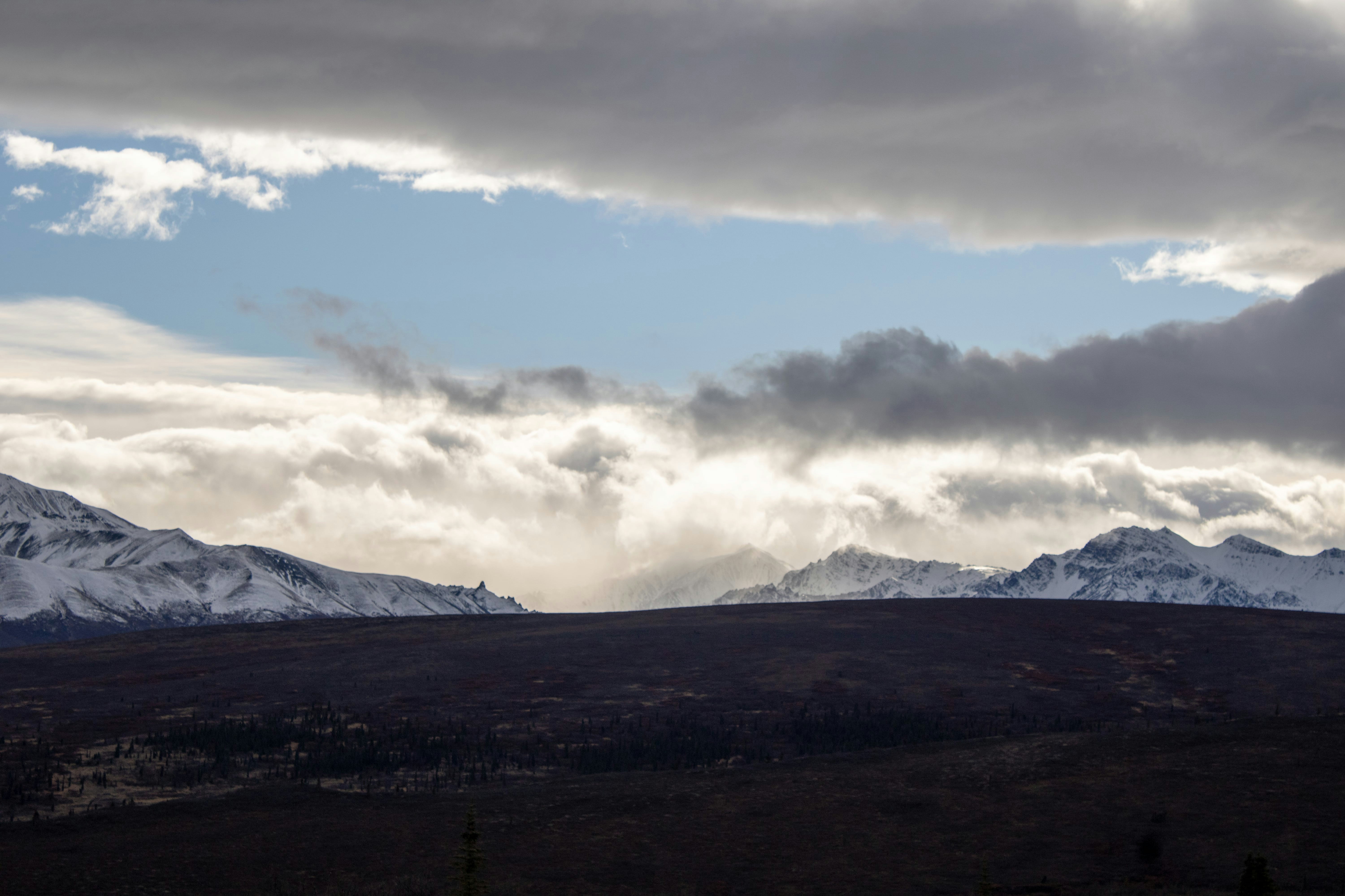 A mountain range with snow capped mountains in the distance