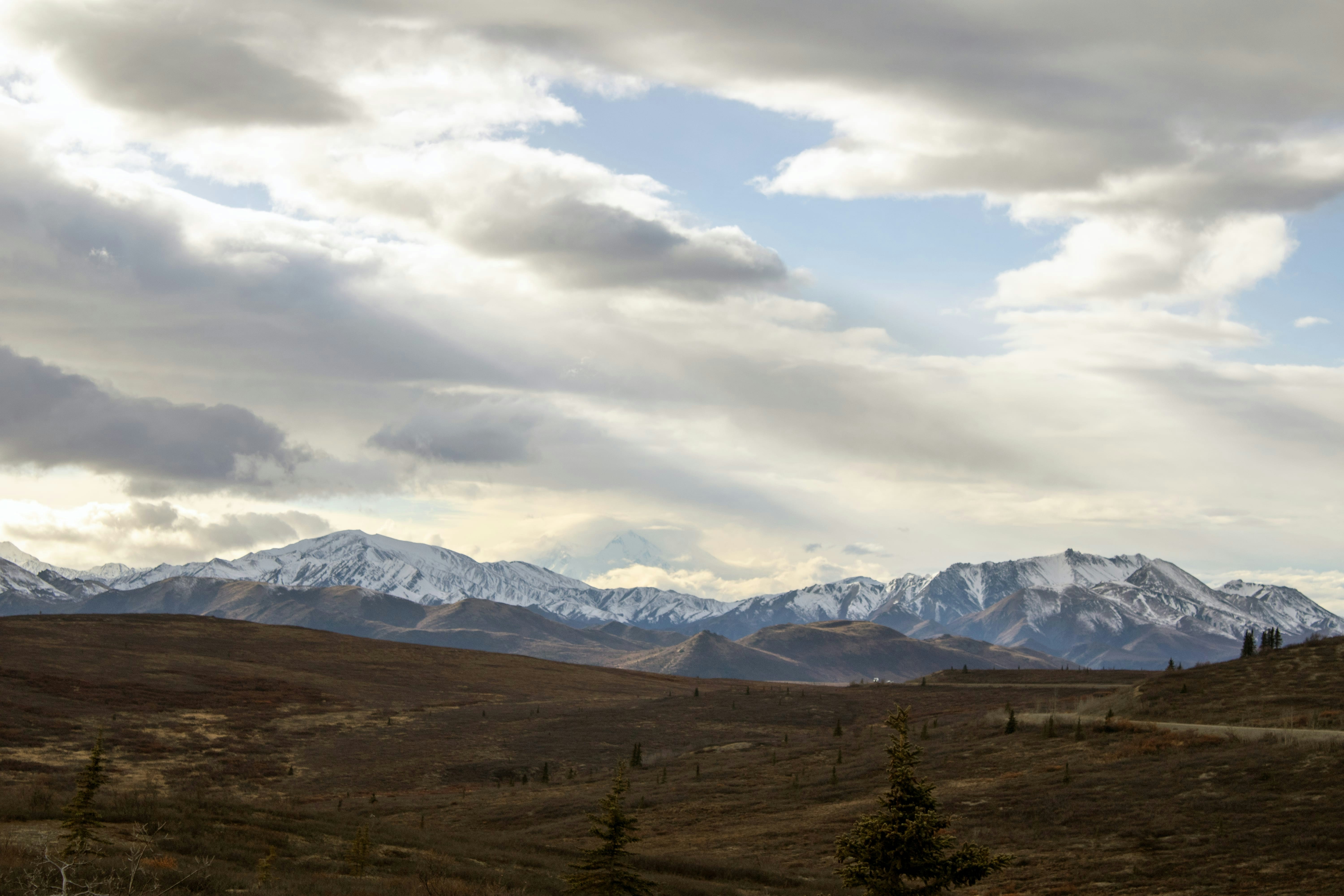 A view of a mountain range with clouds in the sky