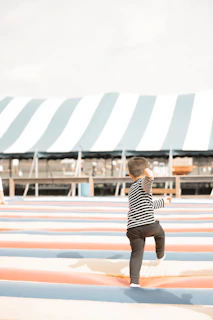A little boy standing on top of a surfboard