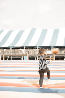 A little boy standing on top of a surfboard