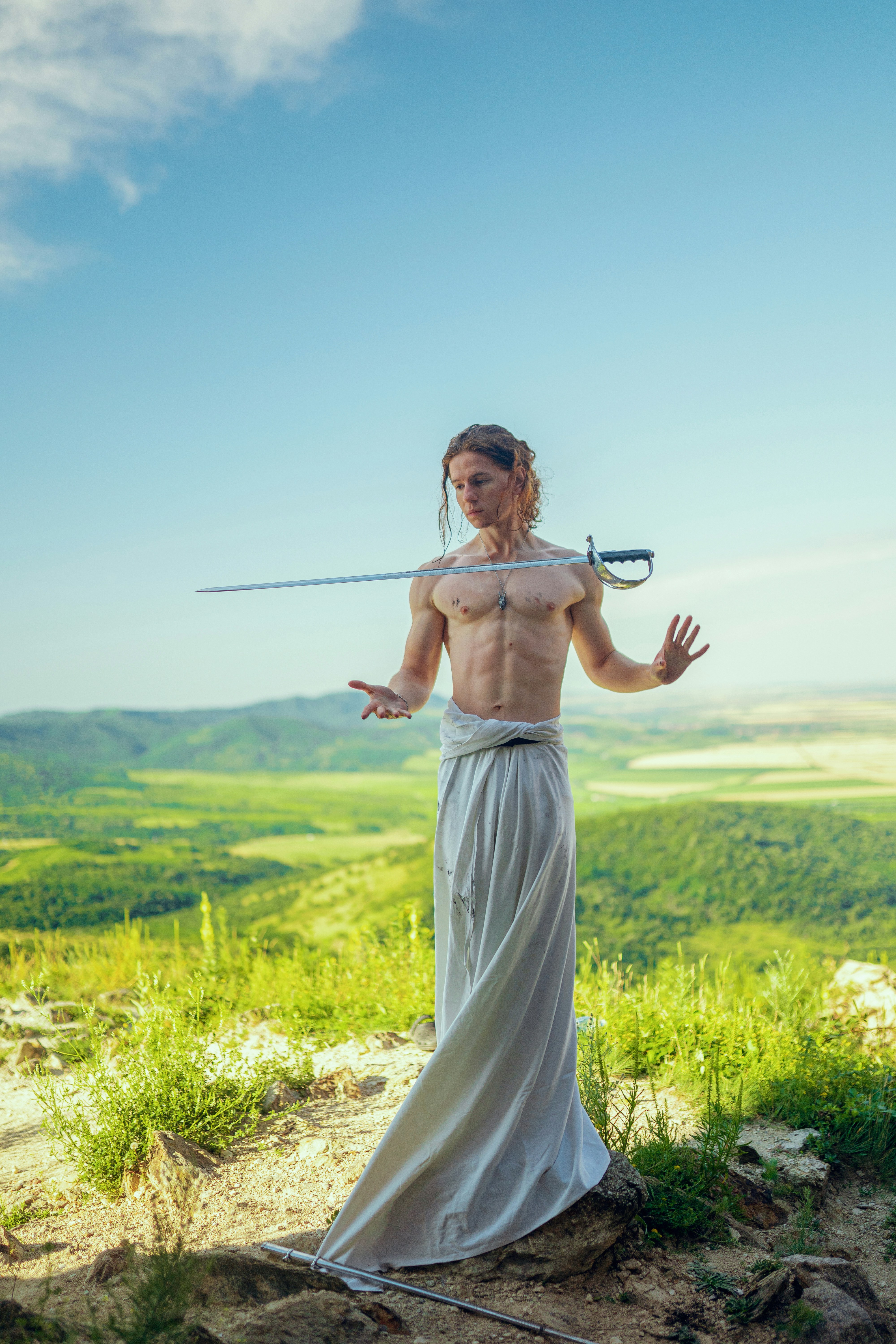 A woman with a sword standing on top of a hill