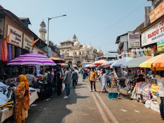 A group of people walking down a street next to shops