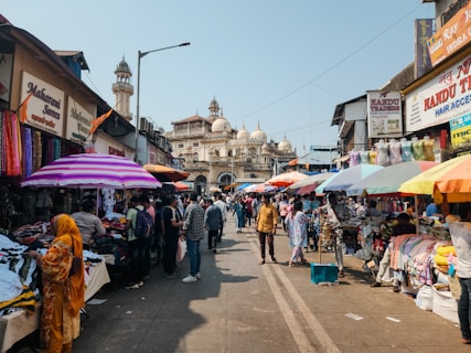 A group of people walking down a street next to shops