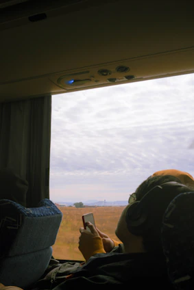 A person sitting in a vehicle looking out the window