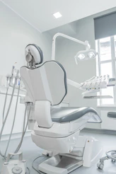 A white dental chair in a room with a window