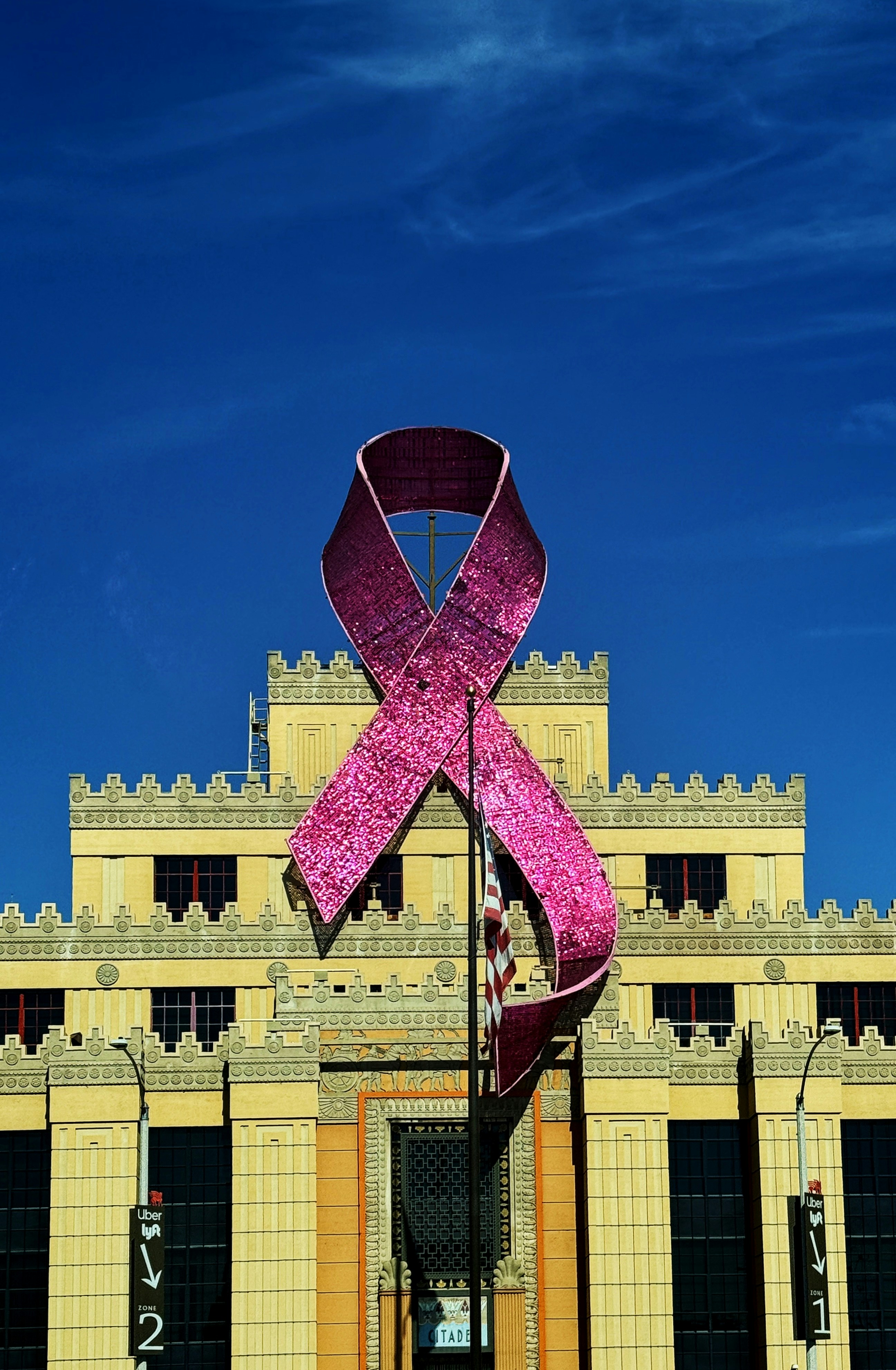 A large pink ribbon on top of a building