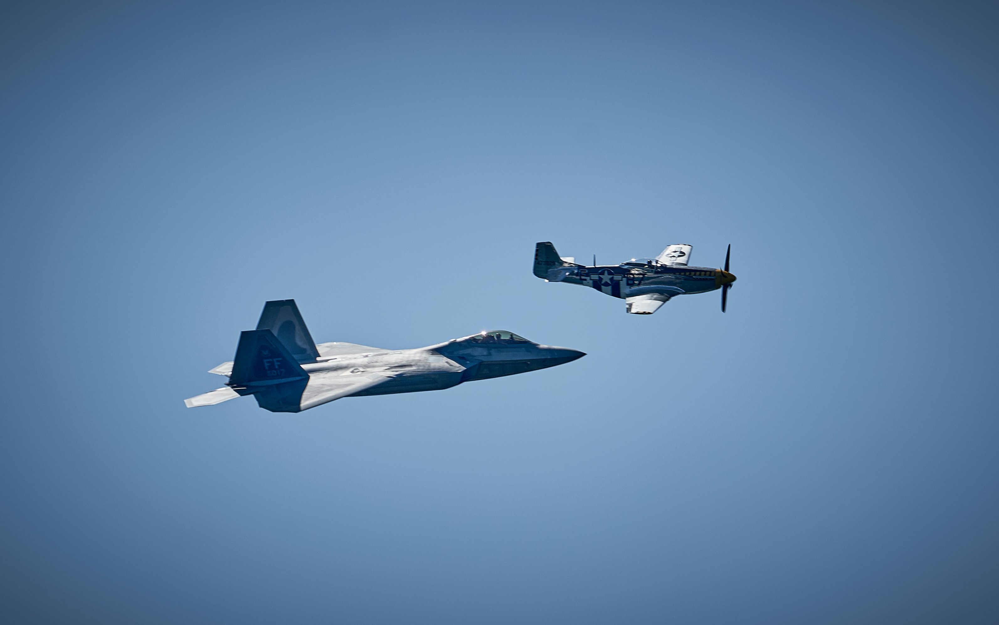 Two planes flying side by side in the sky