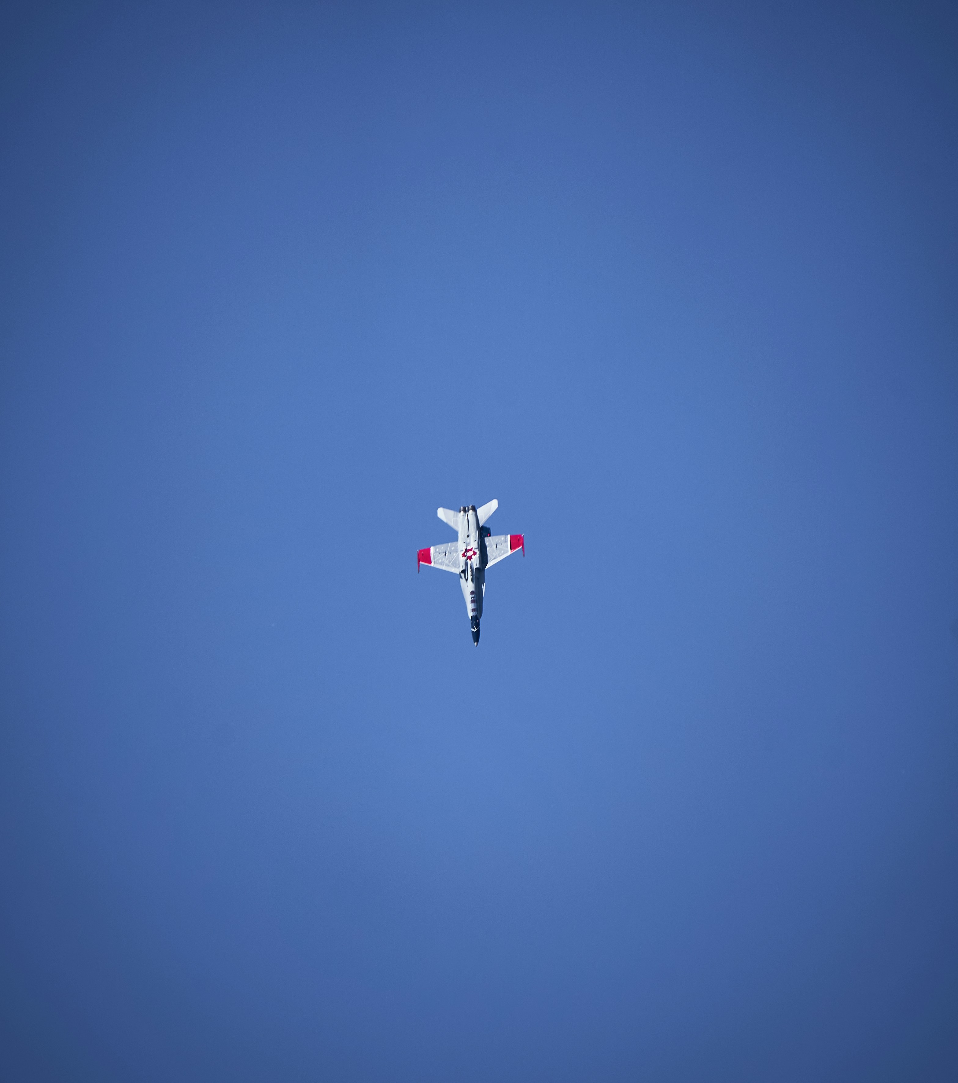An airplane is flying in the blue sky
