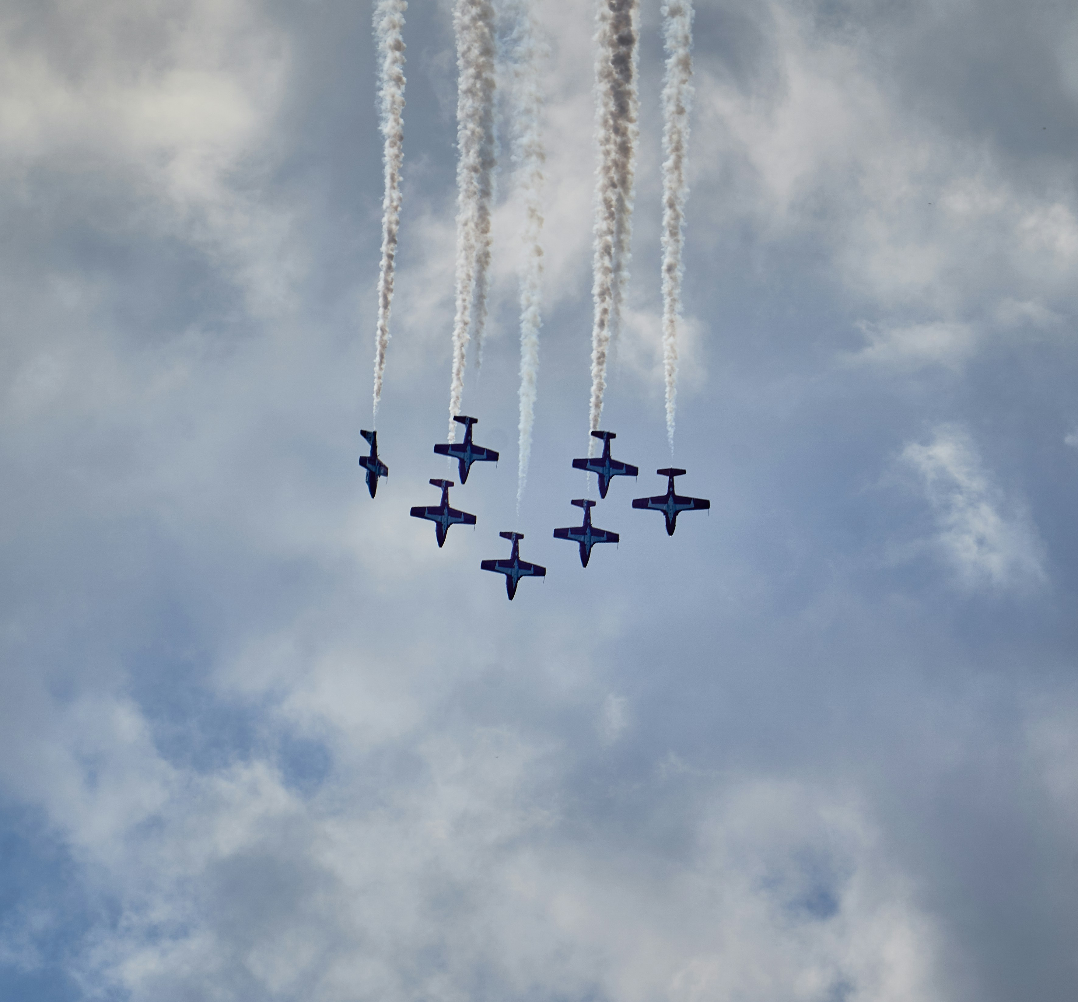 A group of jets flying through a cloudy sky