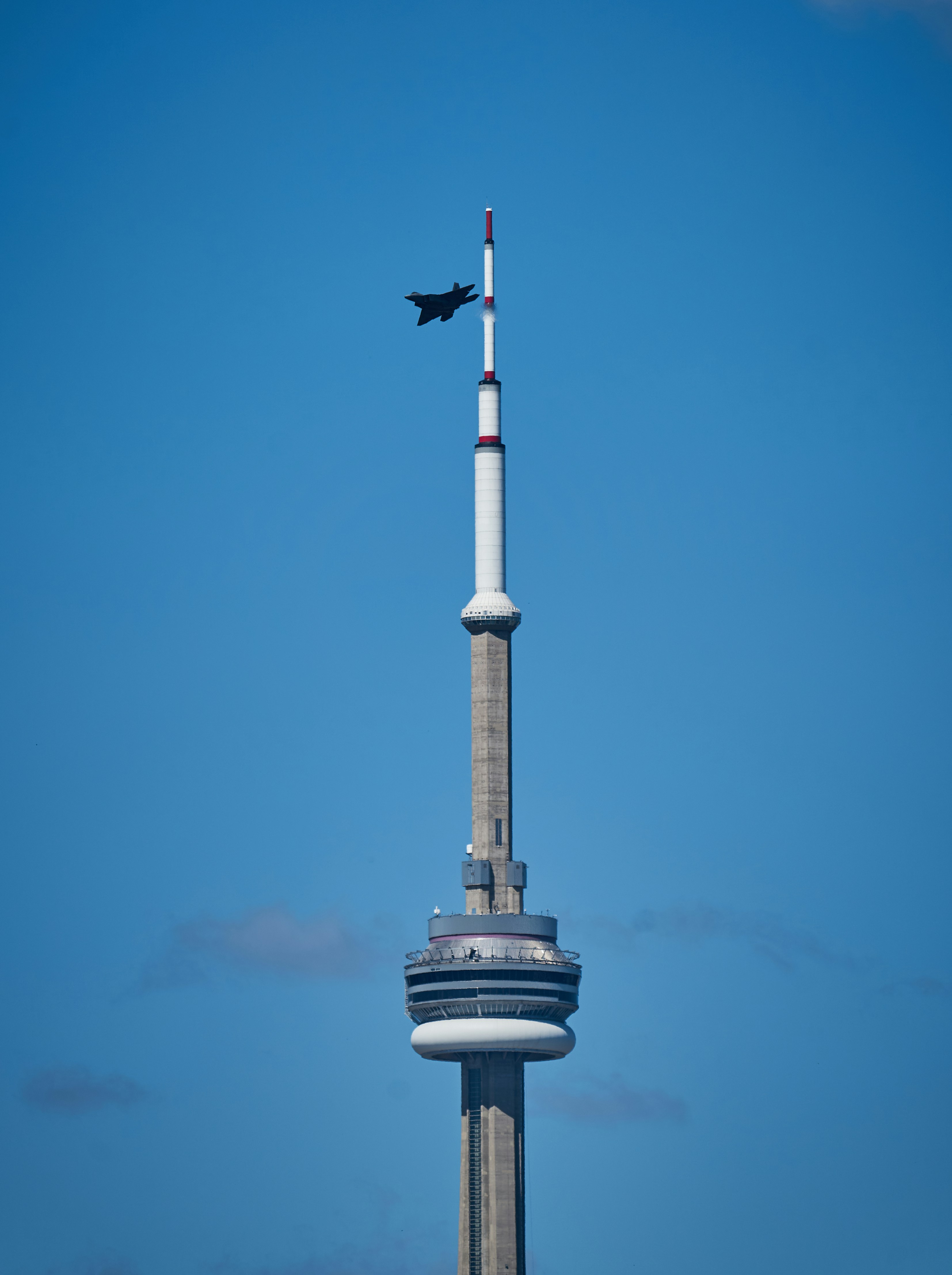 A plane flying over the top of a tall building