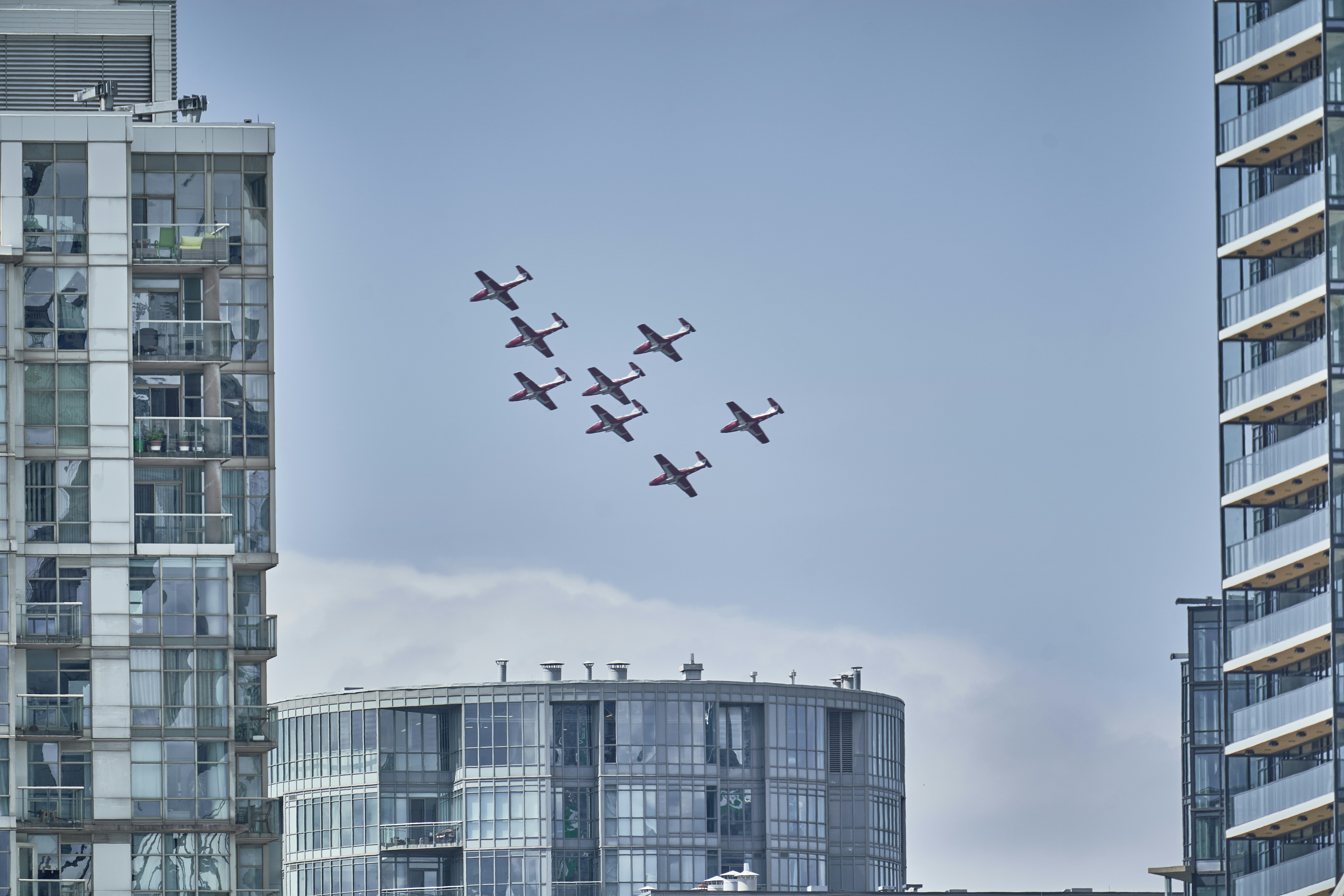 A group of airplanes flying over a city
