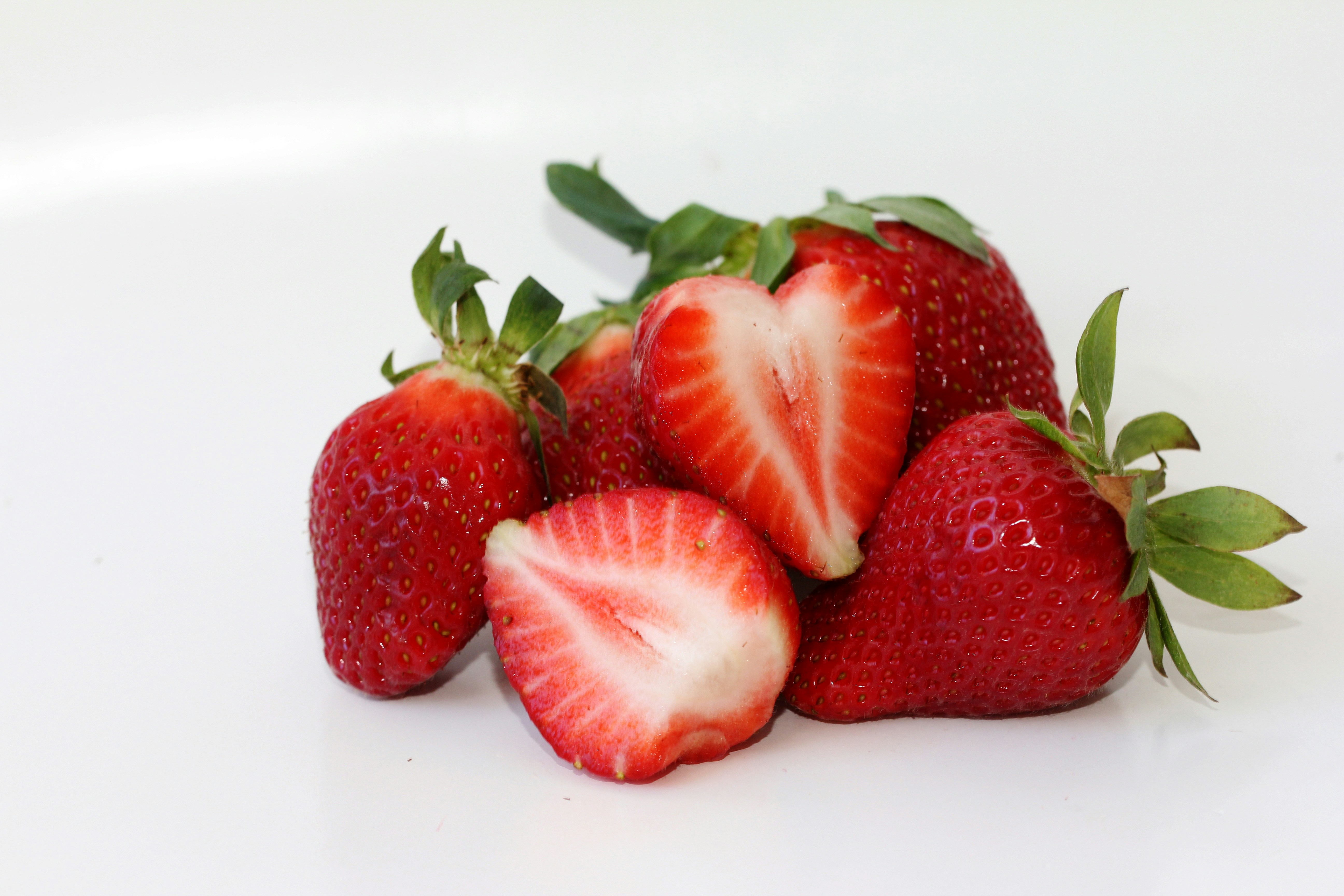 A pile of strawberries sitting on top of a white table